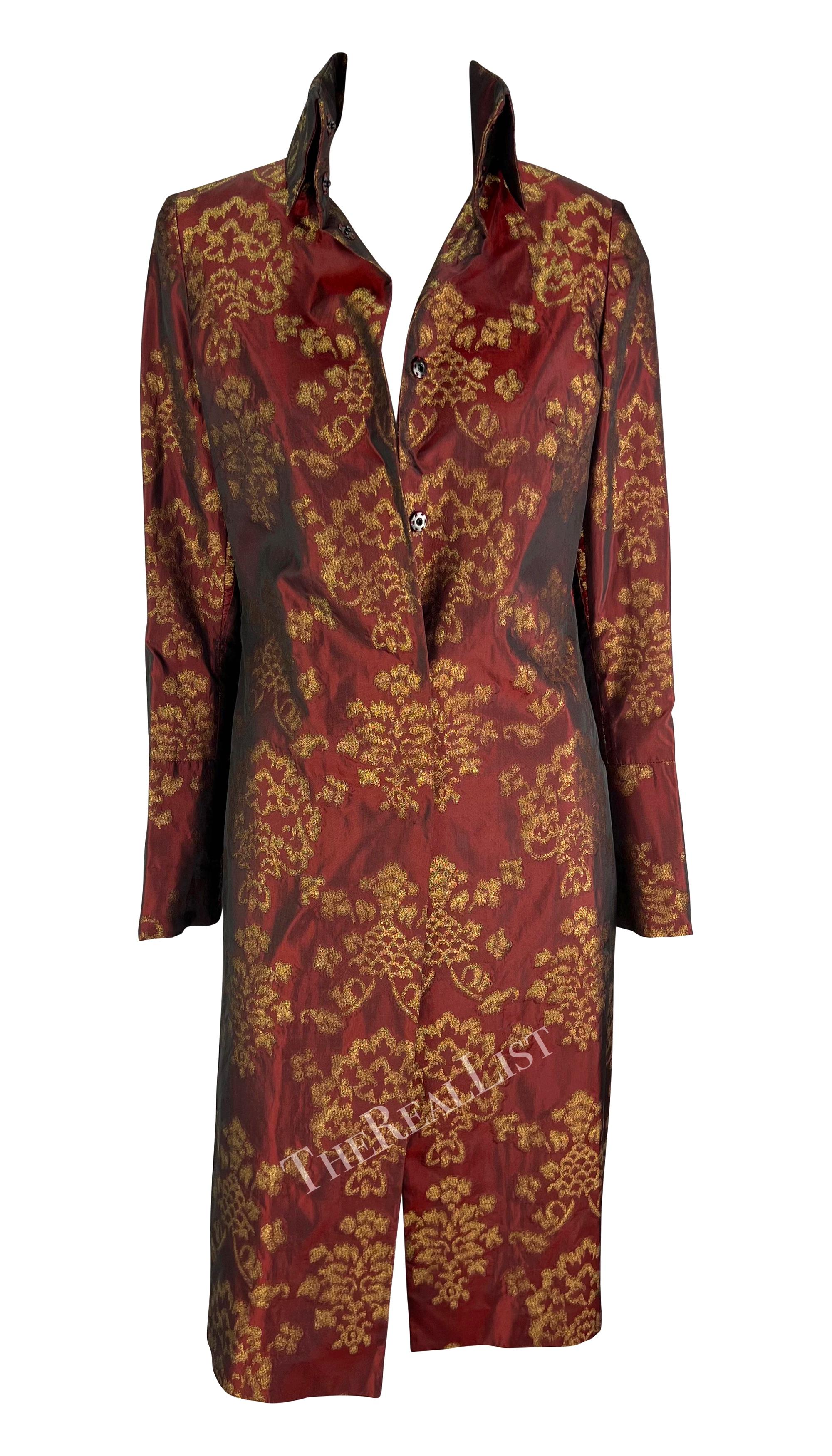 Presenting a fabulous burgundy jacquard silk Dolce & Gabbana knee-length coat. From the Spring/Summer 2000 collection, this chic coat is constructed entirely of burgundy satin jacquard with a beautiful gold-tone scroll pattern woven throughout. This
