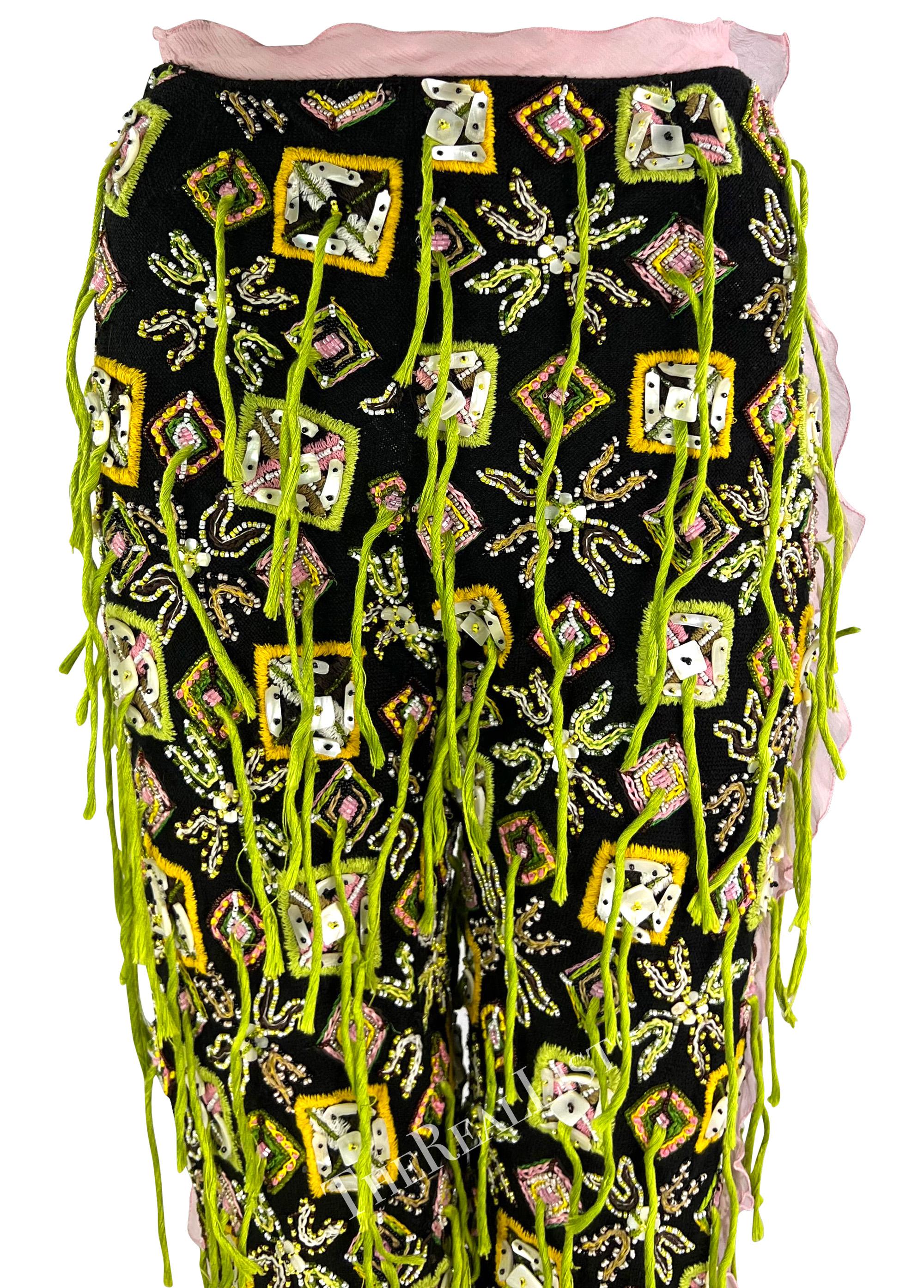 Presenting a pair of incredible black embellished Fendi pants, designed by Karl Lagerfeld. From the Spring/Summer 2000 collection, these black pants are heavily embellished with seed beads, mother-of-pearl, and strands of vibrant green fringe. These