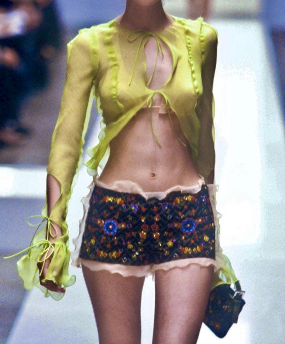 This Fendi sheer chiffon dress from the Spring/Summer 2000 collection by Karl Lagerfeld features an acid green hue with delicate ruffle trim and a plunging front tie closure. Variations of this design debuted on the season's runway and were featured