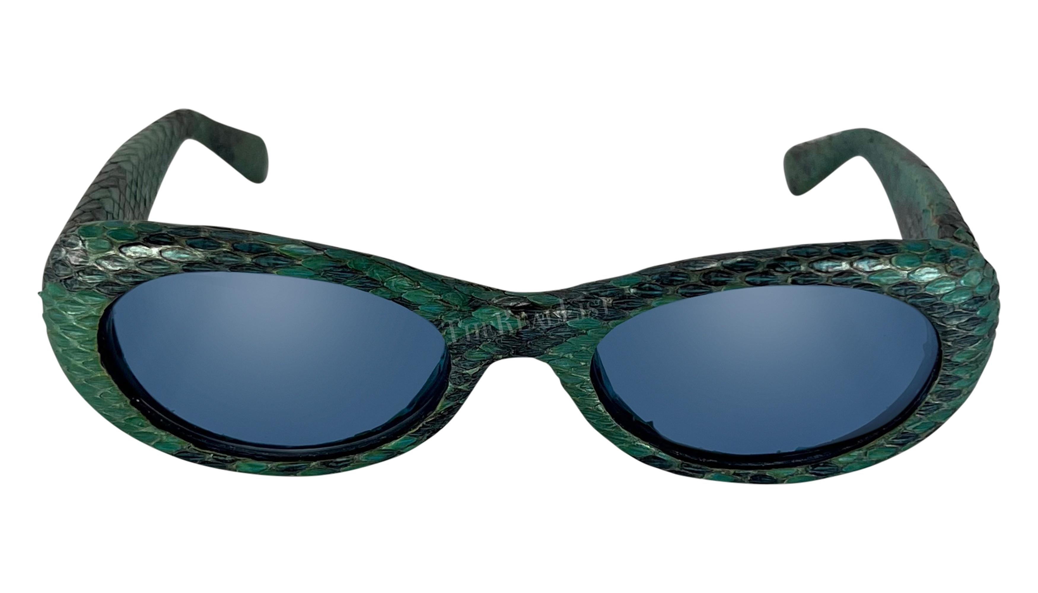 From the Spring/Summer 2000 collection, these blue python Gianni Versace oval sunglasses, designed by Donatella Versace, are covered in blue python skin. The glasses feature light blue lenses and are made complete with a gold studded Greek key