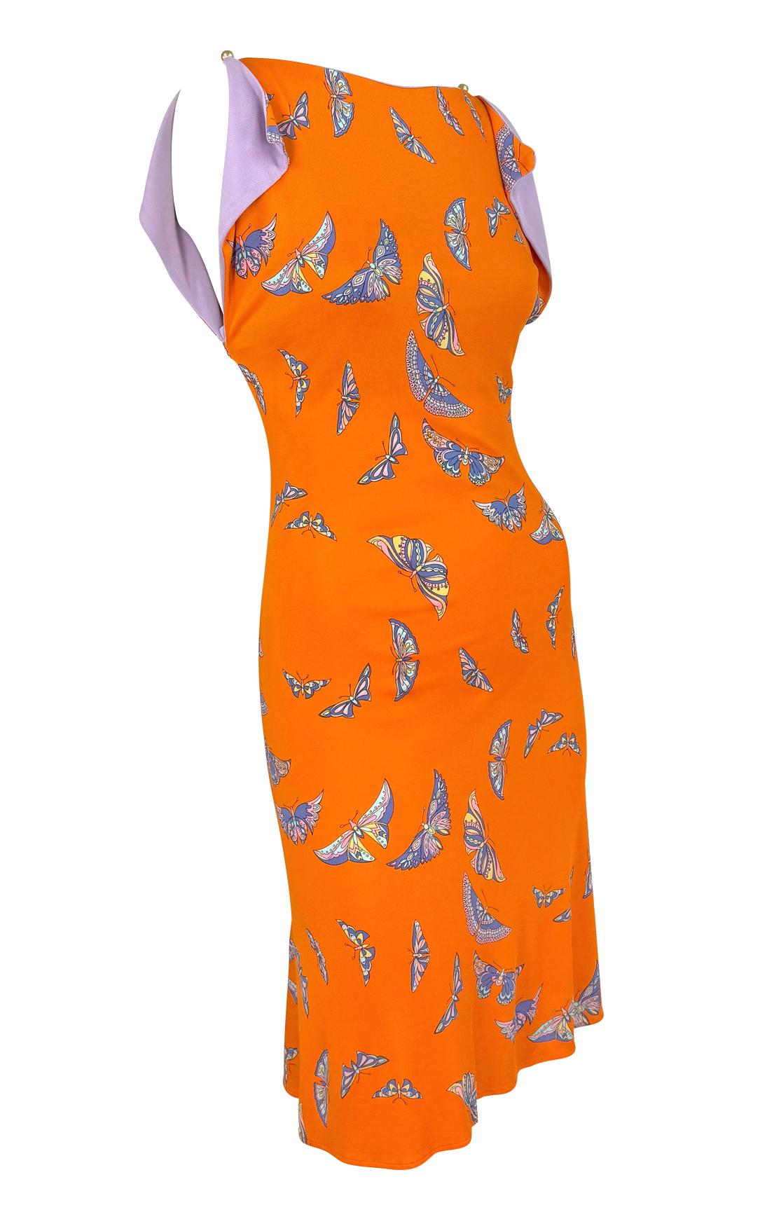 De la colección Primavera/Verano 2000 de Gianni Versace por Donatella, este vibrante vestido acampanado naranja está confeccionado en viscosa y luce un caprichoso estampado de mariposas multicolor. El diseño se completa con una espectacular espalda