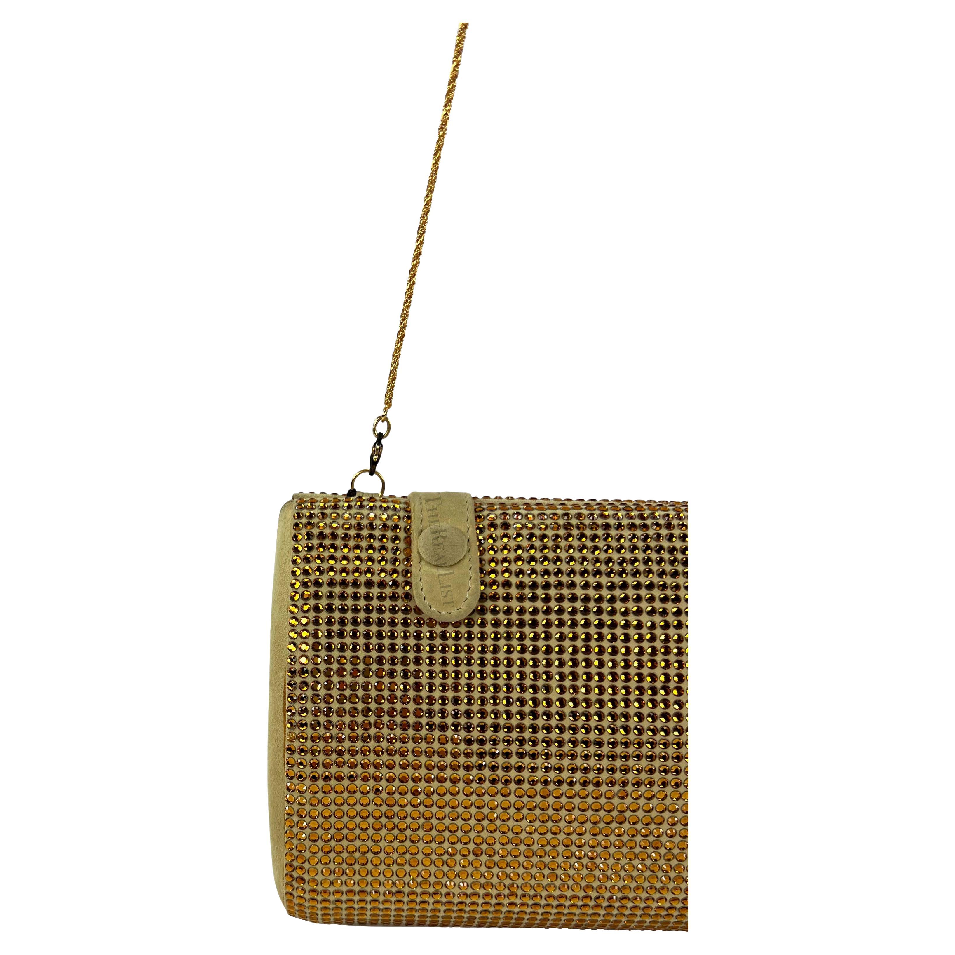 Ti presentiamo una favolosa clutch convertibile di Gianni Versace in camoscio marrone e strass dorati, disegnata da Donatella Versace. Fai una dichiarazione audace con questa fantastica pochette convertibile di Gianni Versace della collezione