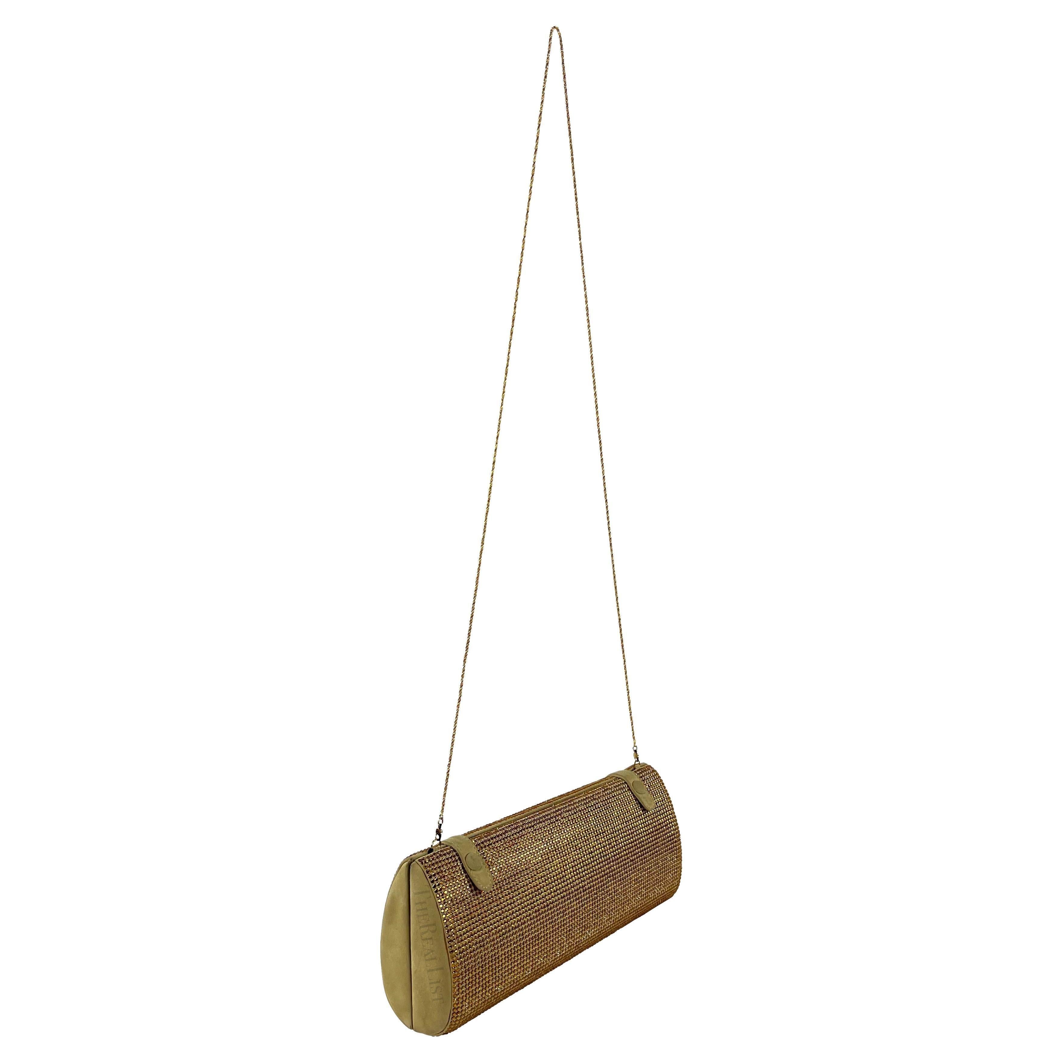 Ti presentiamo una favolosa clutch convertibile di Gianni Versace in camoscio marrone e strass dorati, disegnata da Donatella Versace. Fai una dichiarazione audace con questa fantastica pochette convertibile di Gianni Versace della collezione
