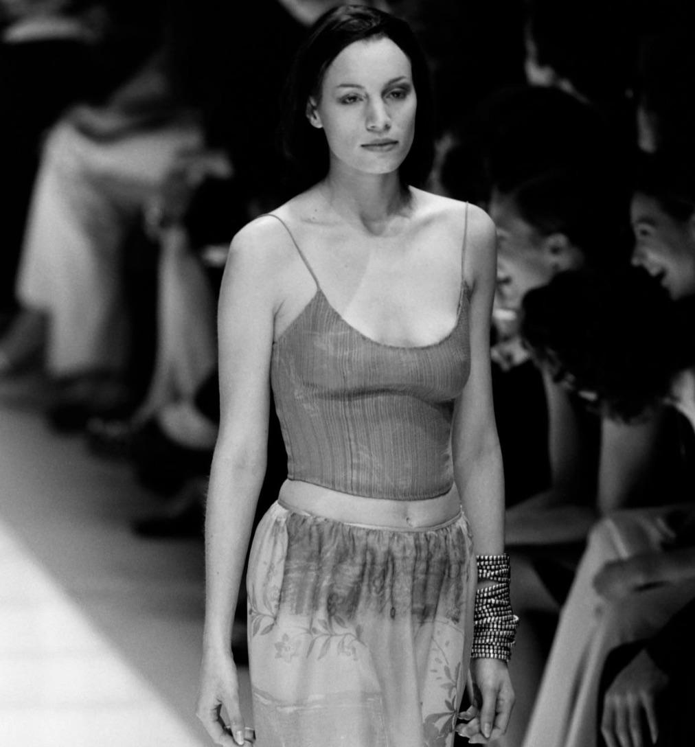 This sheer purple tank top from Giorgio Armani’s Spring/Summer 2000 runway collection is crafted from delicate embroidered silk. Designed with a subtle cropped cut, the piece features tonal vertical stitching and fine spaghetti straps, showcasing