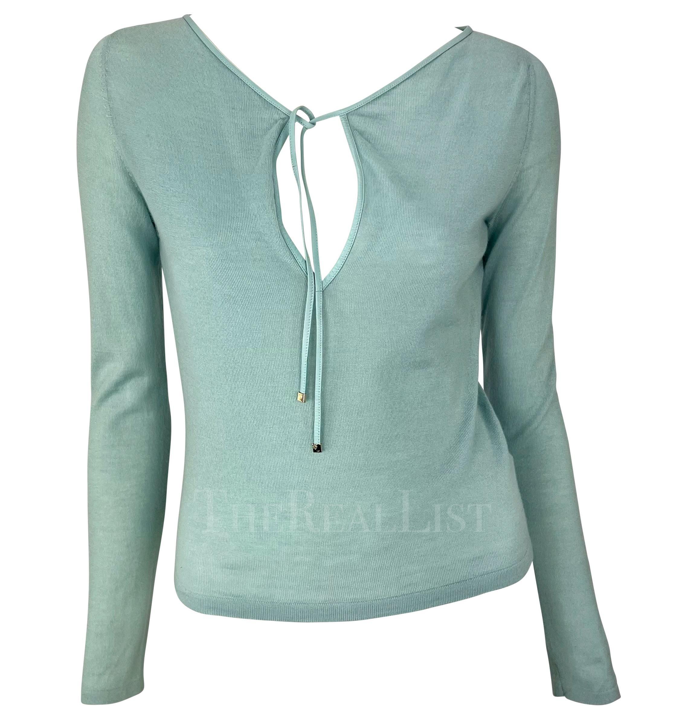 Ti presentiamo un favoloso top Gucci in maglia di cashmere azzurro, disegnato da Tom Ford. Questo top della collezione Primavera/Estate 2000 è realizzato interamente in cashmere e presenta un dettaglio in pizzo di pelle sulla scollatura. Il top è