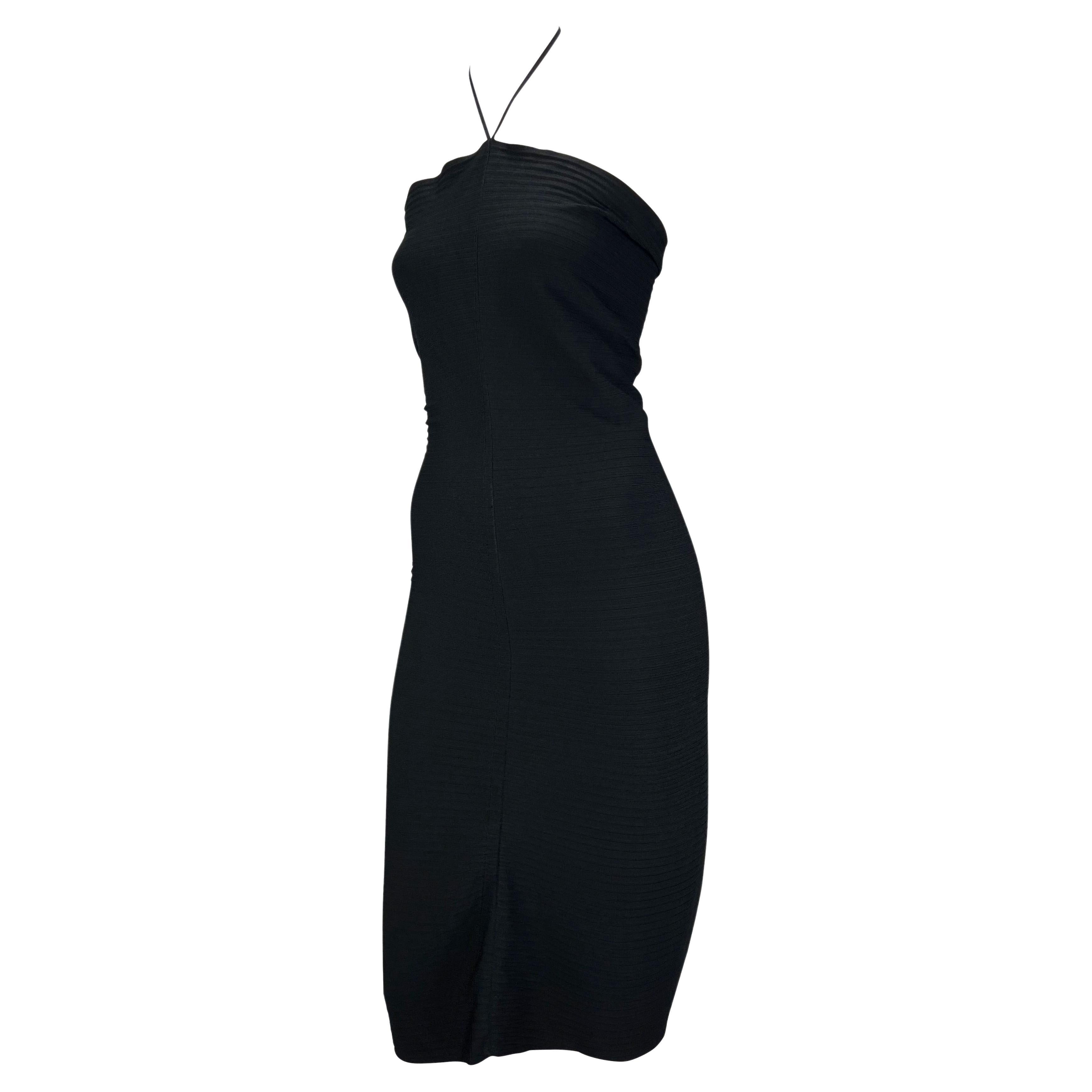 Présentation d'une robe tube Gucci en stretch noir, dessinée par Tom Ford. Issue de la collection printemps/été 2000, cette superbe robe moulante est dotée d'un dos nu et d'une fermeture en métal estampillé 