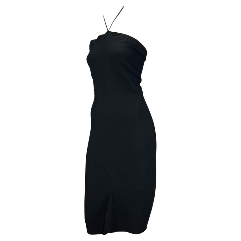 TheRealList presents: a black stretch Gucci tube dress, designed by Tom Ford. From the 2000 Spring/Summer collection, this stunning form-fitting dress is made complete with a halterneck with a 'Gucci' stamped metal closure at the neck. This