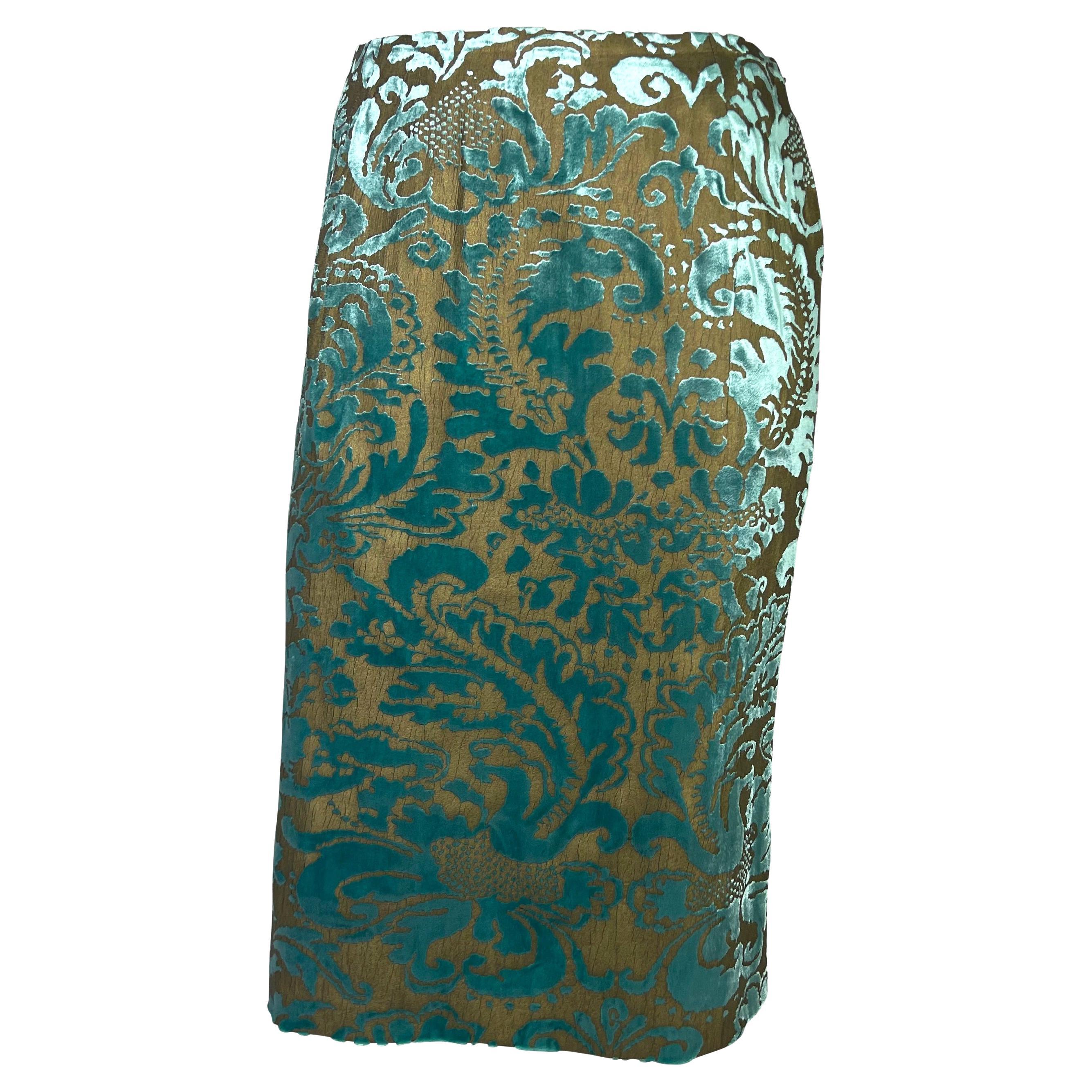 Presenting a gorgeous bronze and teal velvet Gucci skirt sample, designed by Tom Ford. From the Spring/Summer 2000 collection, this teal velvet skirt is made complete with a bronze paint overlay that creates a floral pattern. Never created for mass