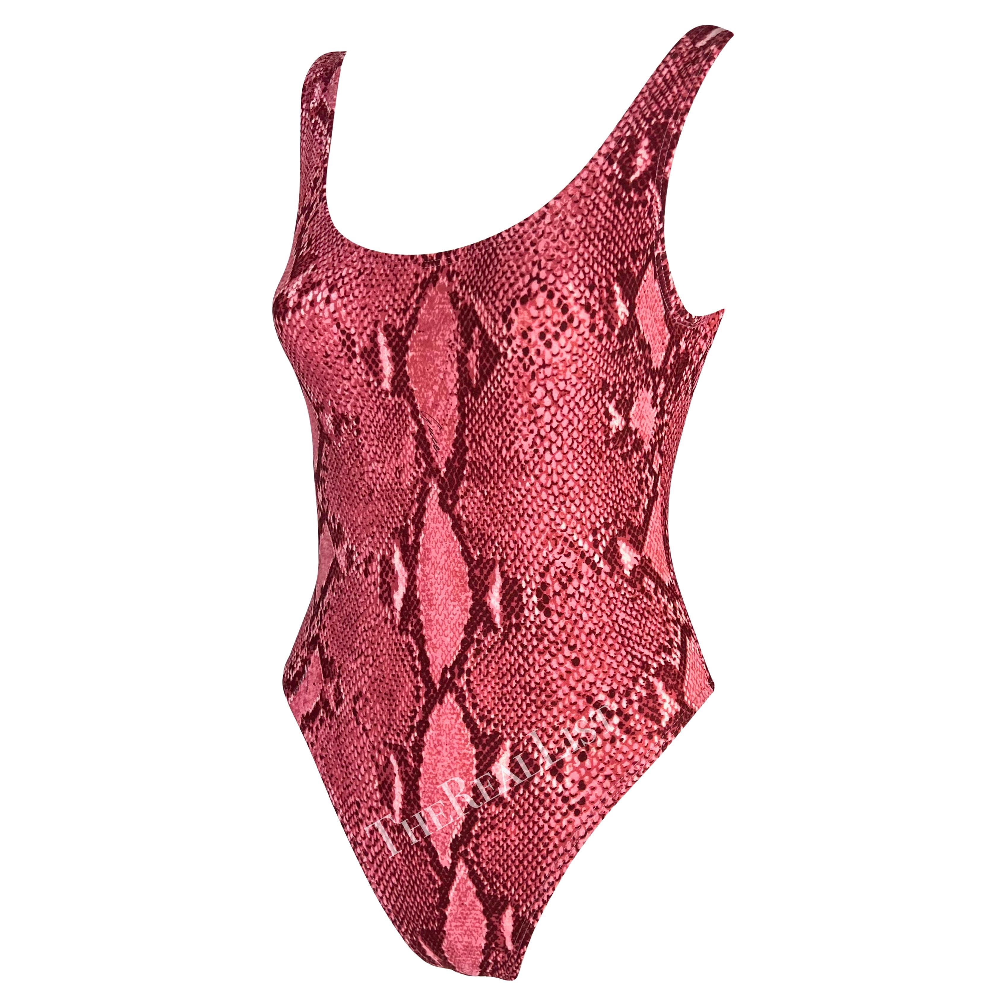 Presenting a bright pink snakeskin print Gucci one-piece swimsuit, designed by Tom Ford. From the Spring/Summer 2000 collection, this one-piece bathing suit/bodysuit is covered in a snakeskin print that was heavily used in the season's collection.