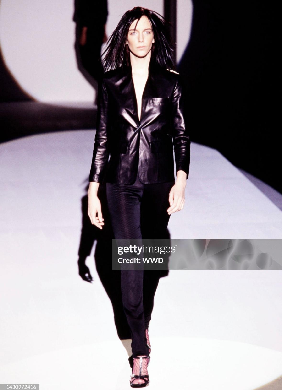 This black leather blazer by Gucci, designed by Tom Ford for Spring/Summer 2000, was featured on the runway as Look 22, modeled by Hannelore Knuts. Crafted from supple leather, it features peak lapels, a single-button closure, and oversized front