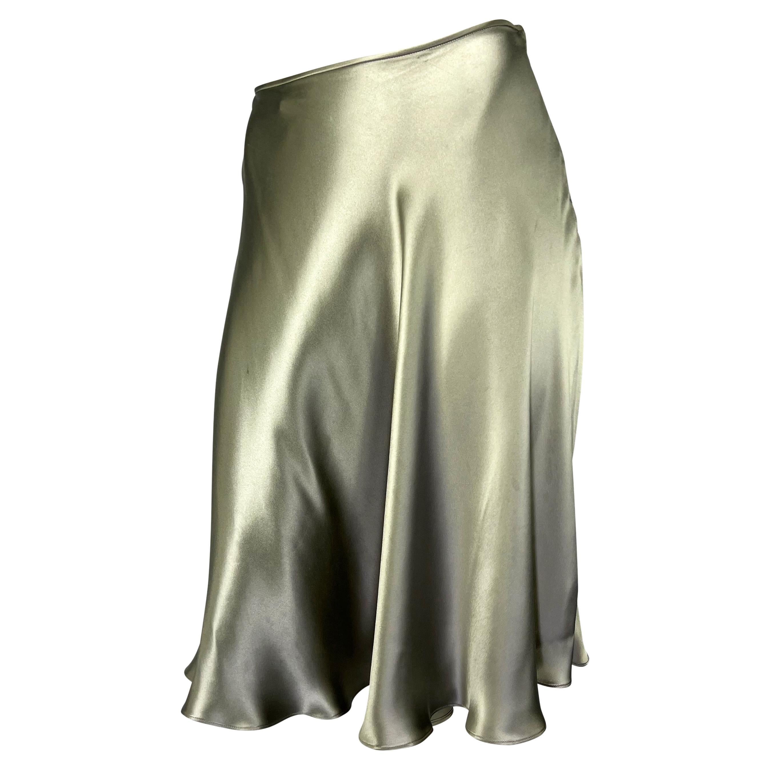 TheRealList presents: a shining silver Gucci skirt designed by Tom Ford. From the Spring/Summer 2000 collection, this silk satin skirt features a flare cut. The perfect piece to bring shimmer to any ensemble, this skirt encapsulates Ford's masterful