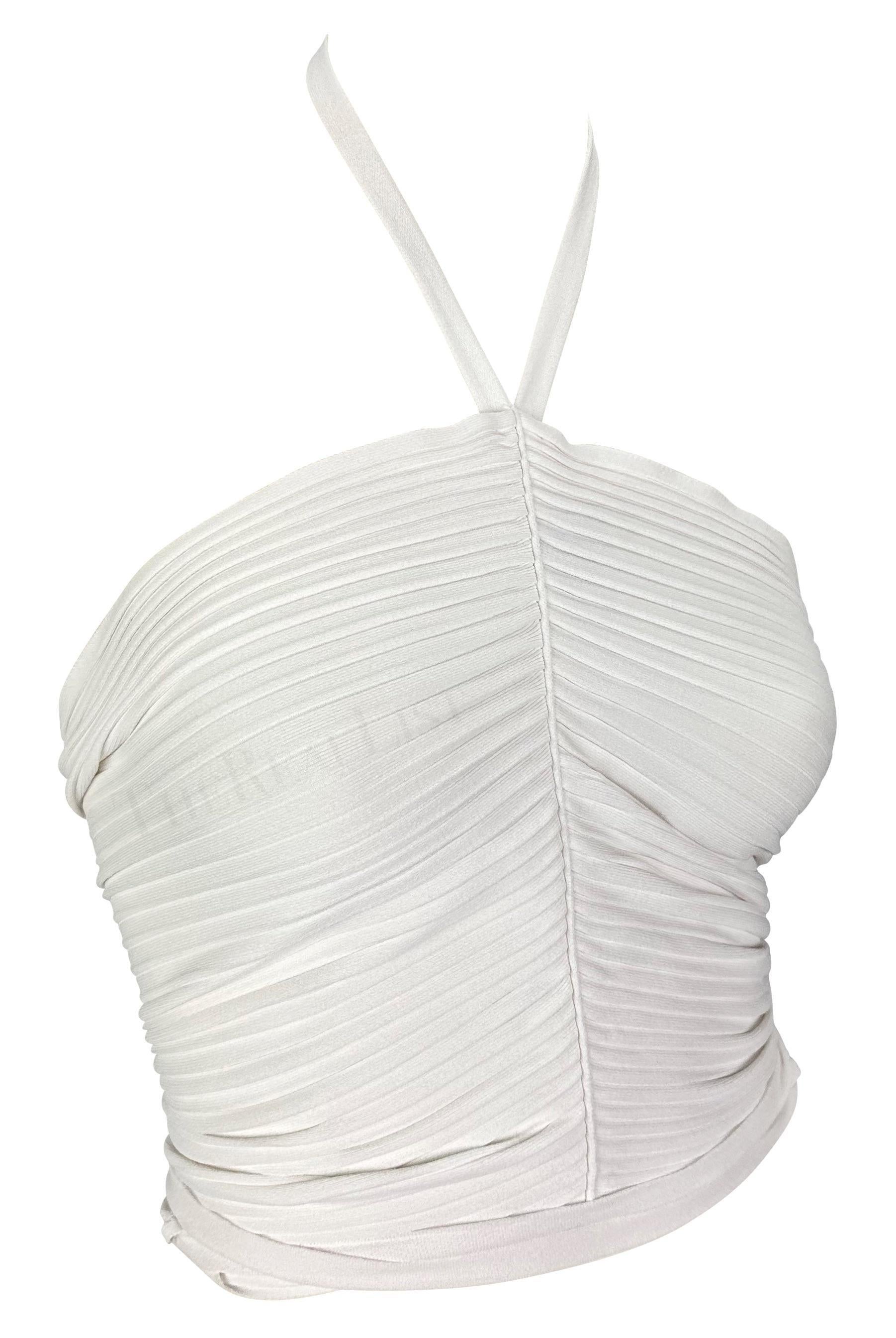 Présentation d'un top blanc croisé à col licou Gucci, conçu par Tom Ford. Issu de la collection Printemps/Eté 2000, ce top côtelé épouse le corps. Doté d'une couture sur le devant, ce haut décolleté est naturellement ruché et complété par un lien
