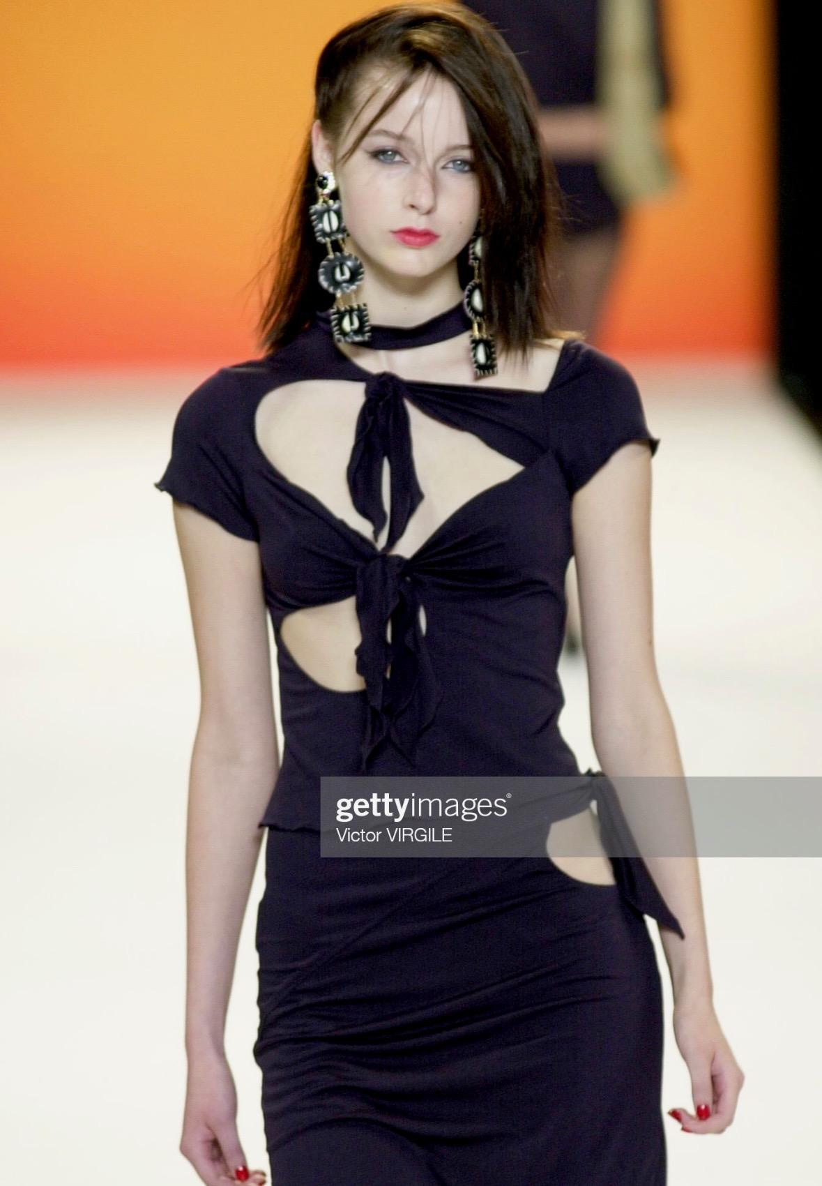 Presenting a fabulous black Anna Sui tie top. From the Spring/Summer 2001 collection, a version of this top debuted on the season's runway as part of look 4, modeled by Jenny Vatheur. This slashed stretch t-shirt features ties throughout the front
