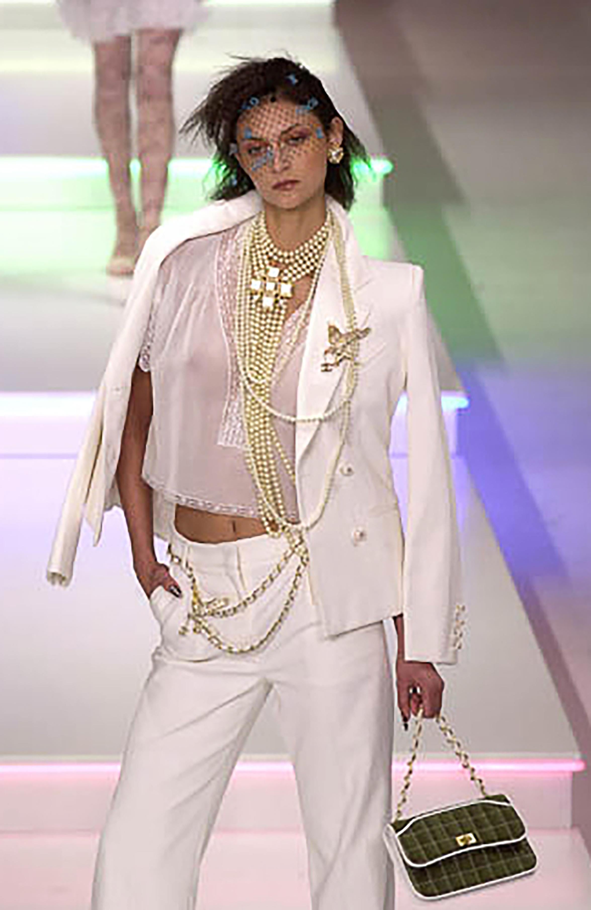 S/S 2001 Chanel by Karl Lagerfeld double-breasted white suit set. Double-breasted blazer jacket with stamped pearl buttons. Mid-rise trousers with slight flare. Suit featured on the runway, and on Renee Zellweger for 
