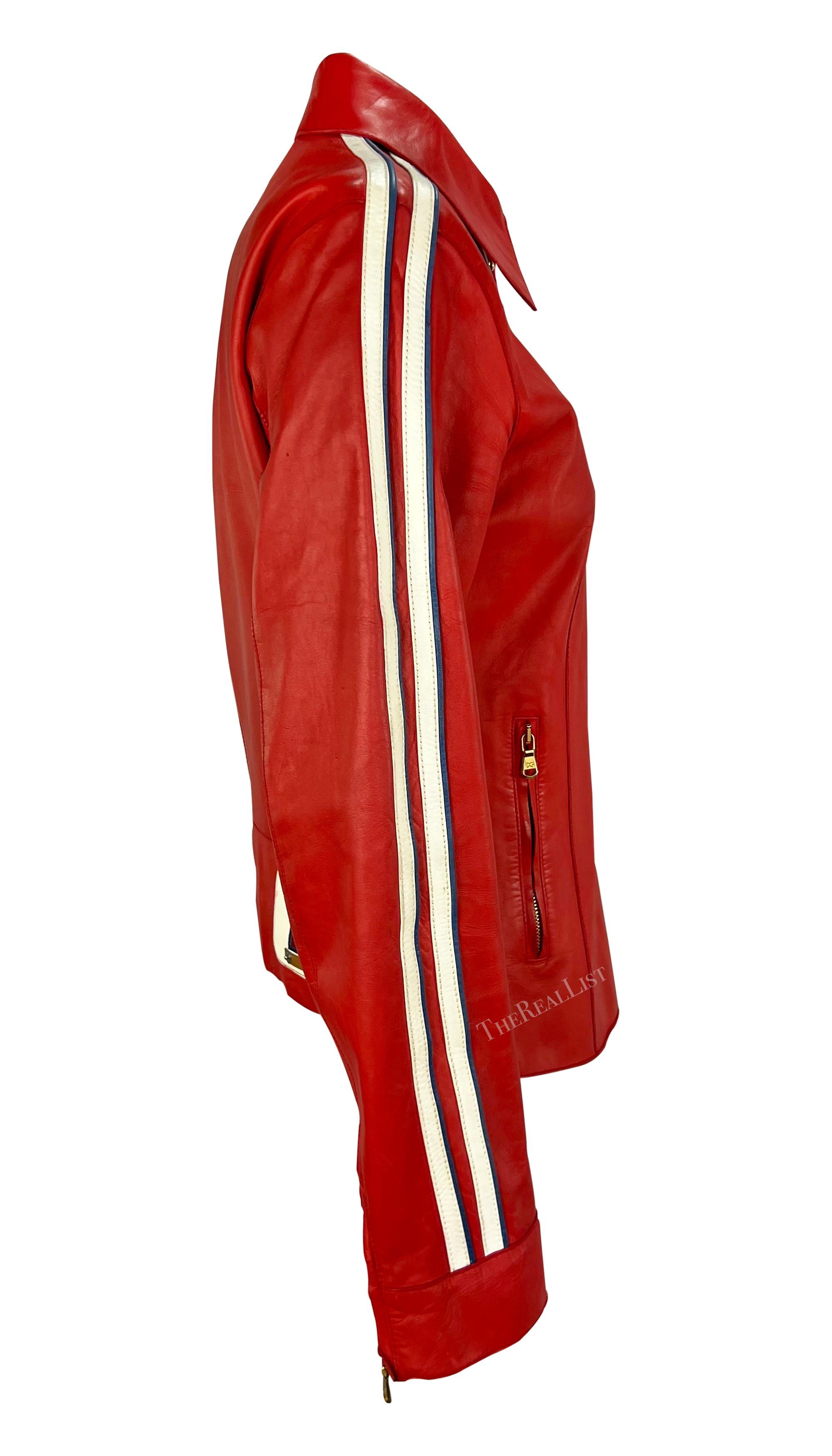 Presenting a chic red leather Dolce & Gabbana moto jacket. From the Spring/Summer 2001 collection, this jacket features a fold-over collar, white stripes that run along the arms, and a small ’21’ accent at the back. The jacket is made complete with