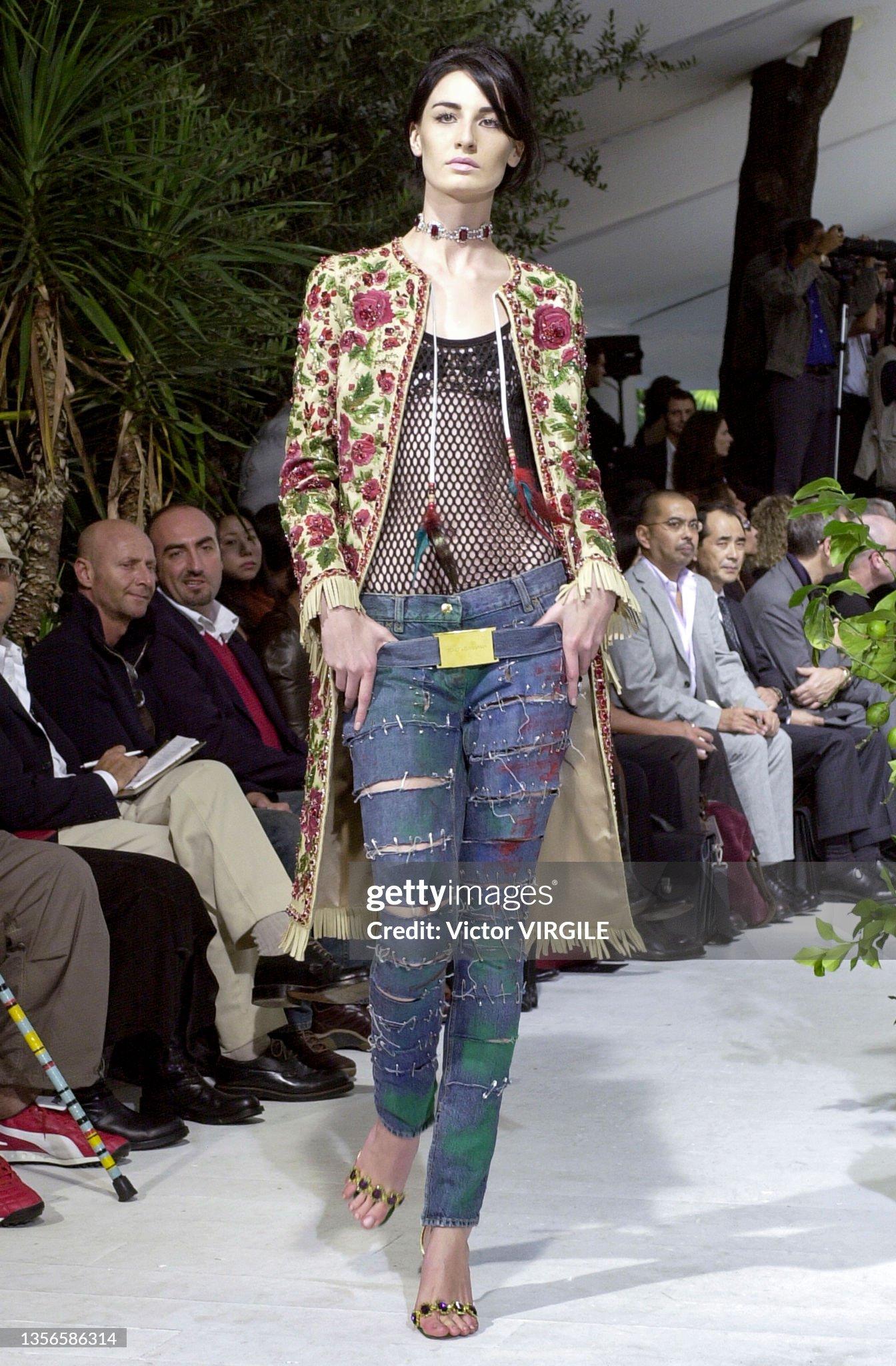 Diese Skinny-Jeans von Dolce & Gabbana aus der Frühjahrskollektion 2001, die von Erin O'Connor in Look 23 modelliert wurde, weist mit Sicherheitsnadeln zusammengehaltene Risse auf, die für einen rebellischen, dekonstruierten Look sorgen. Handgemalte