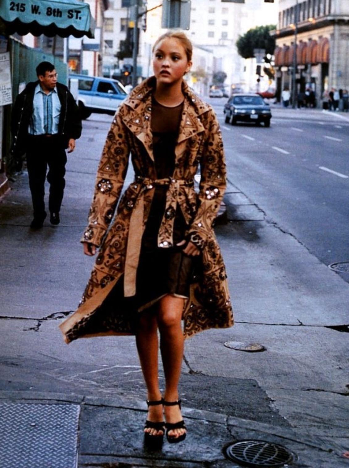 Presenting a gorgeous tan suede Dolce & Gabbana trench coat. From the Spring/Summer 2001 collection, this coat is covered in a hand done floral embellishment with beads and small mirrors throughout. This embellishment first debuted on the season’s