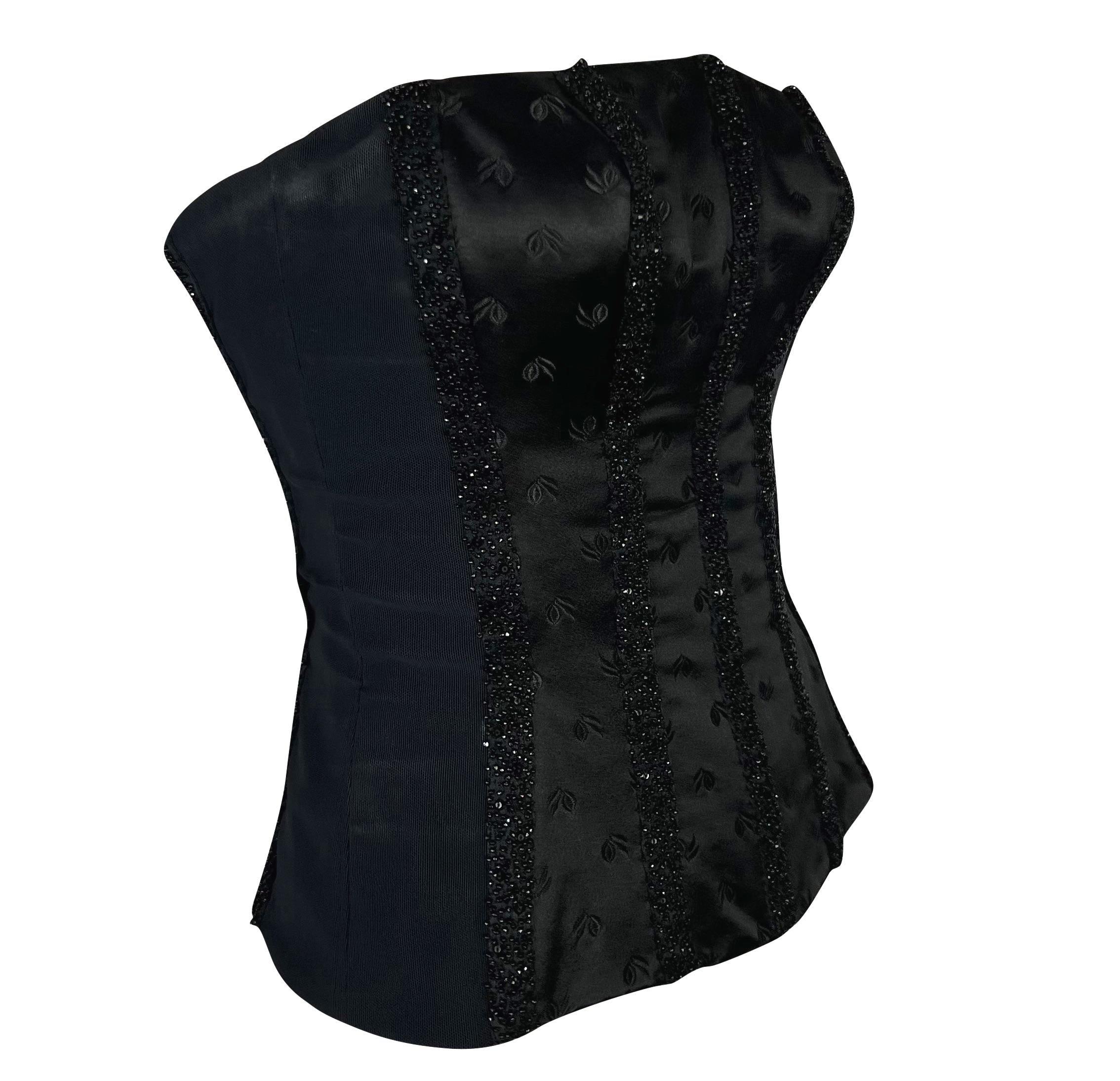 Ti presentiamo uno splendido corsetto senza spalline in raso nero di Donatella Versace for Gianni Versace. Questo bellissimo top senza spalline della collezione Primavera/Estate 2001 ha una vita stretta e una struttura a corsetto. Il design a