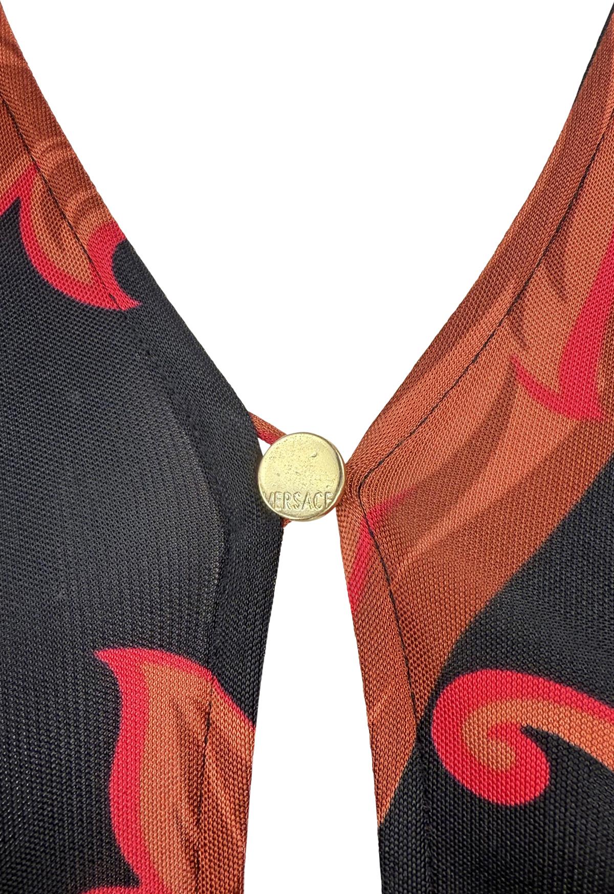 From Gianni Versace’s Spring/Summer 2001 collection by Donatella, this black bodycon dress features a bold red baroque print, a plunging keyhole neckline with a gold-tone clasp, and a front slit.

Approximate measurements:
Size - 40IT/6US
Bust: 28 -