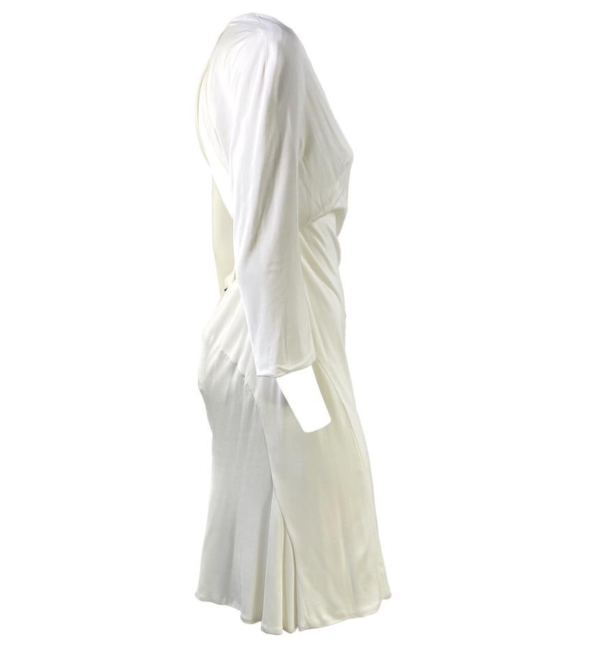 Presenting a white backless Gianni Versace dress, designed by Donatella Versace. A seemingly simple long sleeve v-neck dress from the front that will turn heads with a fully open back. This dress features a small clasp featuring a brand nameplate at