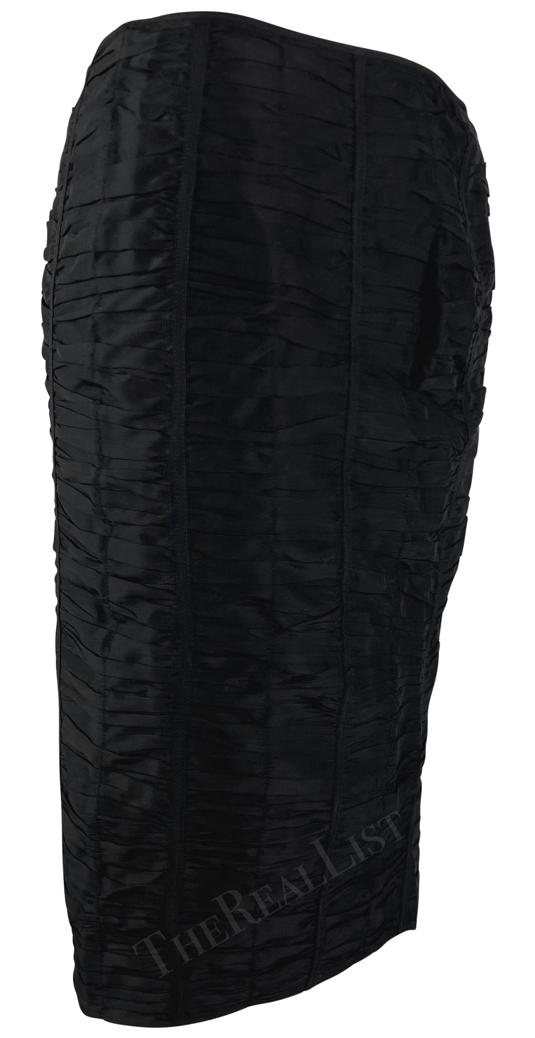 Collectional présente une jupe noire froncée de Gucci, conçue par Tom Ford et issue de la collection printemps/été 2001. Cette jupe en soie est ornée de rubans cousus et comporte une fente au dos. 

Mesures approximatives :
Taille - 38IT
De la