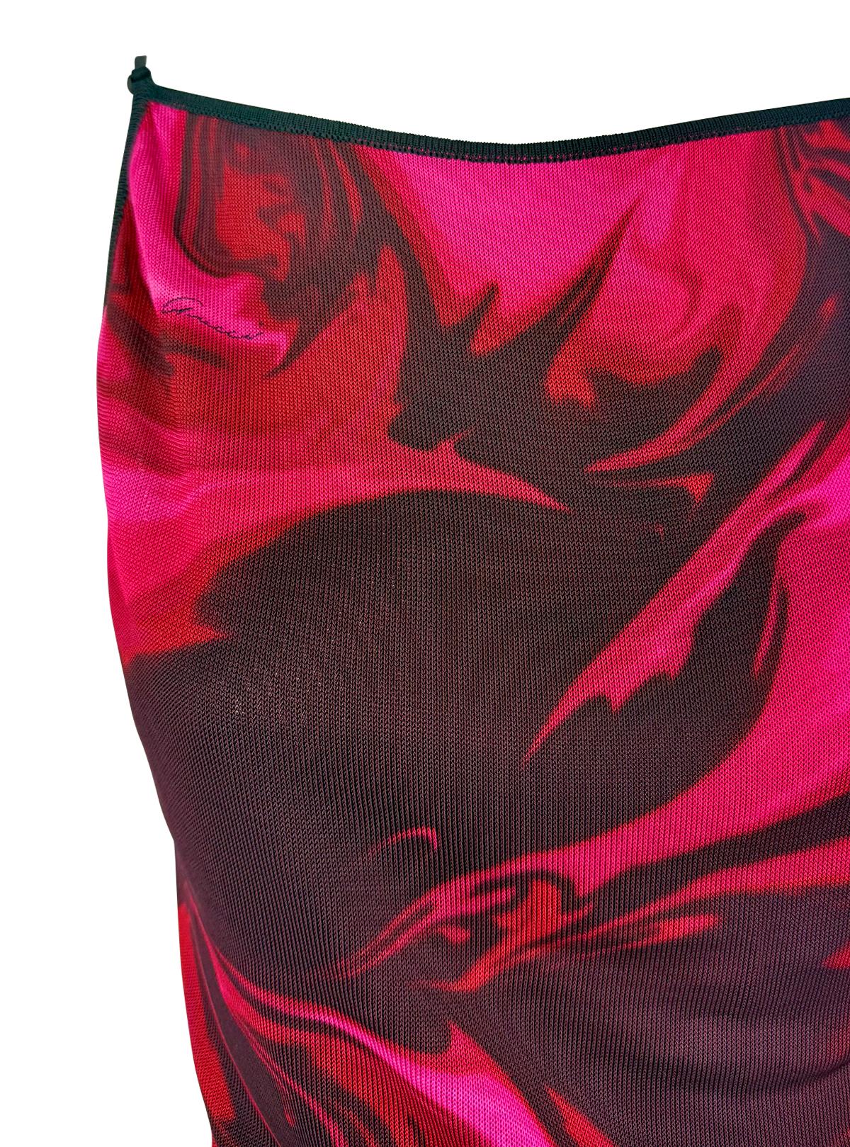 Presentamos una llamativa camiseta de tirantes con estampado de logotipo de efecto líquido de la colección Primavera/Verano 2001 de Gucci, diseñada por Tom Ford. Confeccionado en una ligera malla elástica, este top sin espalda presenta un estampado