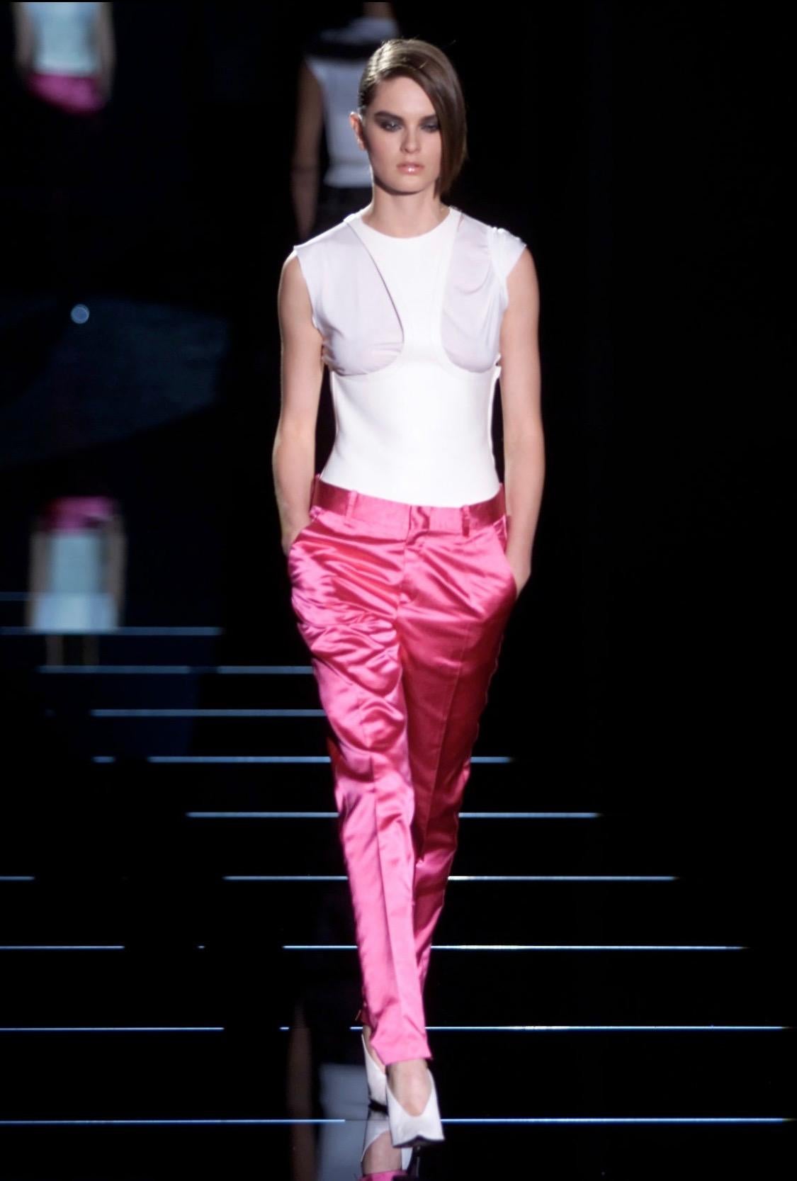Présentation d'un pantalon Gucci en satin rose vif, conçu par Tom Ford. Ce pantalon incroyable a fait ses débuts sur le défilé printemps-été 2001 du Look 23, porté par Anouck Lepère. Entièrement réalisé en satin de soie lustré, ce pantalon brille à