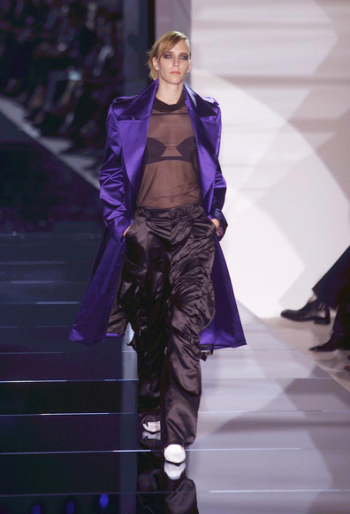 Wir präsentieren ein schwarzes Gucci Oberteil mit durchsichtigem Mesh-Ausschnitt, entworfen von Tom Ford. Dieses Oberteil aus der Collection'S Spring/Summer 2001 wurde auf dem Laufsteg in Look 5 von Hannelore Knuts, in Look 6 von Eleonora Bose und