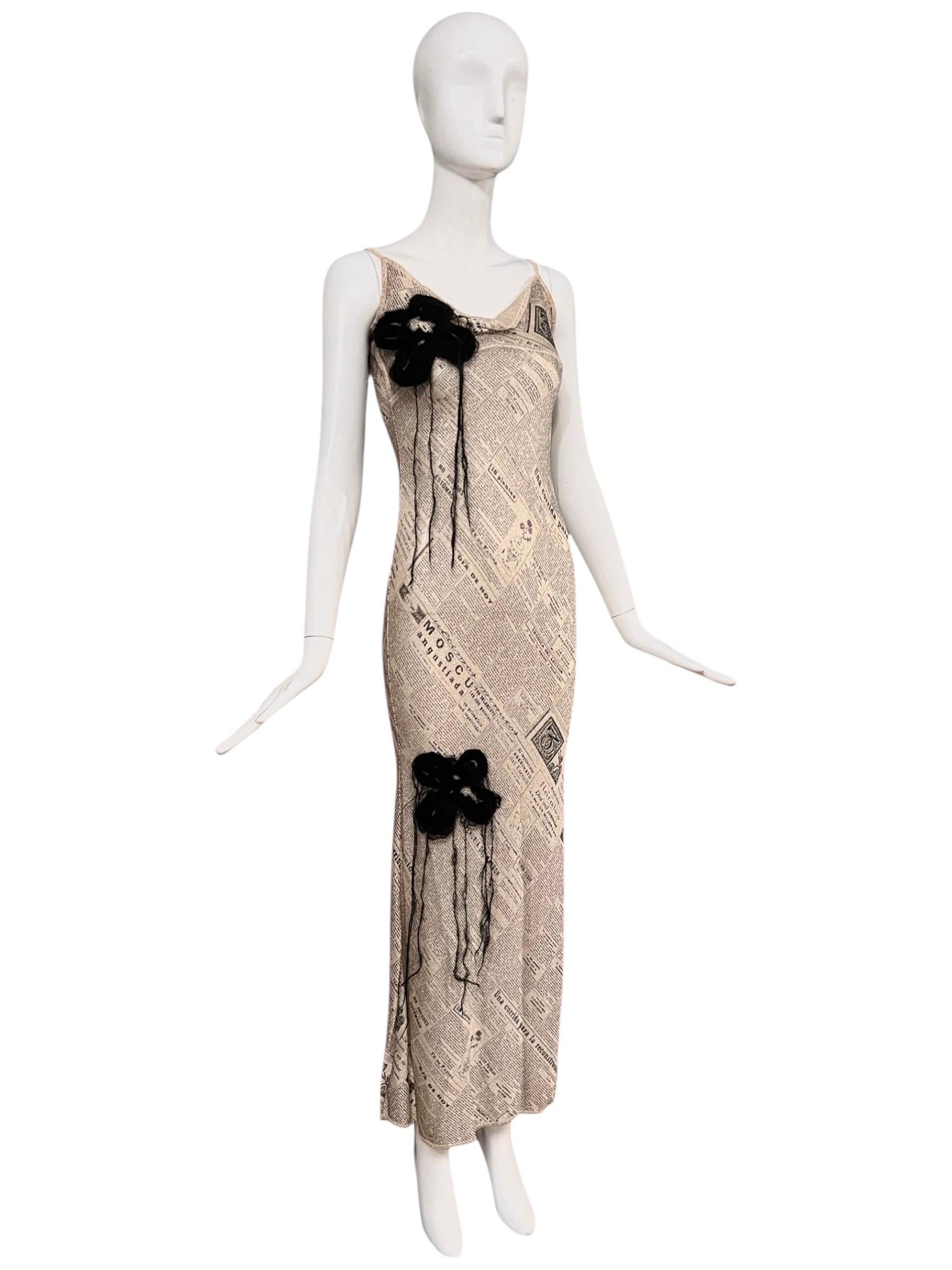 Ein exquisites, archiviertes Stück aus der Frühjahr/Sommer 2001 Kollektion von John Galliano. Dieses elfenbeinfarbene, bodenlange Kleid ist aus einem luxuriösen Stoff gefertigt, der mit goldfarben schimmerndem Lurex verwoben ist und bei jeder