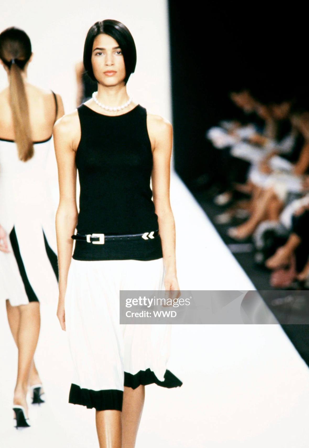 From the Spring/Summer 2001 collection, this fabulous black and off-white pleated Ralph Lauren Purple Label skirt debuted on the season's runway as part of look 17, modeled by Teresa Lourenco. This chic tennis-style skirt features pleats throughout