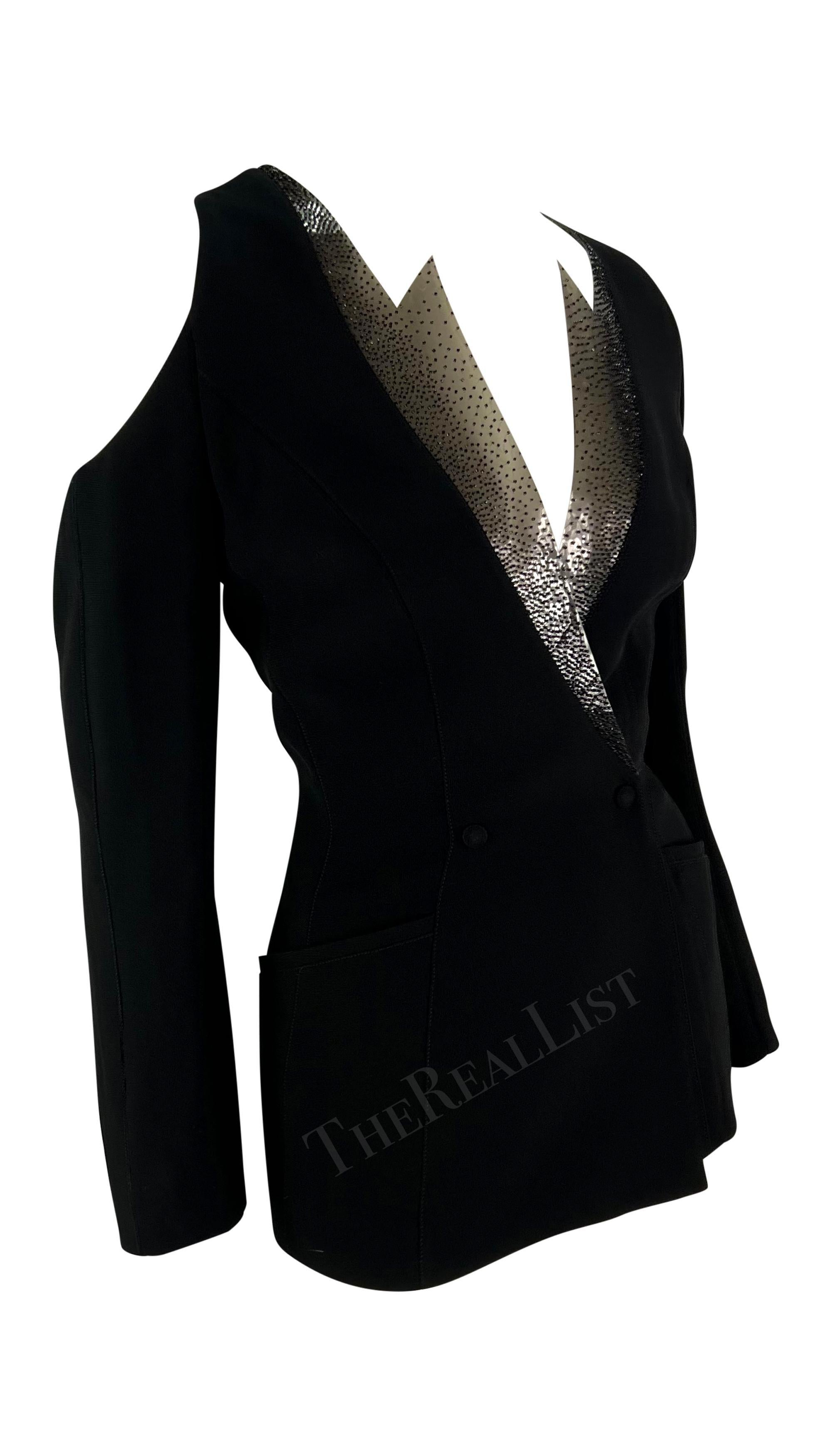 Voici un magnifique blazer noir Thierry Mugler, dessiné par Manfred Mugler. Issue de la collection printemps/été 2001, cette veste a fait ses débuts sur les podiums de la saison. Définie par ses accents angulaires pointus en PVC perlé à l'encolure,