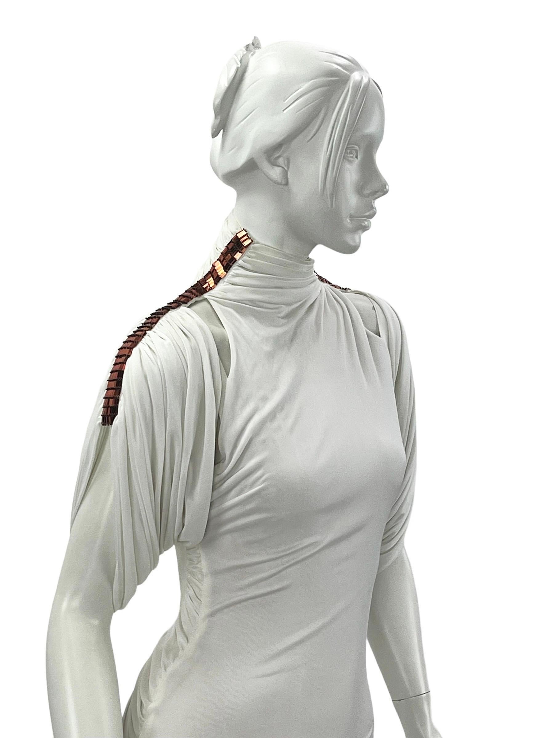 Vintage Gianni Versace Couture Vestido Blanco de Cuello Alto Adornado con Espalda Abierta. 
Colección S/S 2001
Talla 38 - US 2
Jersey elástico blanco, Lentejuelas color cobre, Acabado con body de tul nude, Estilo slip-on, Cierre con botones en el