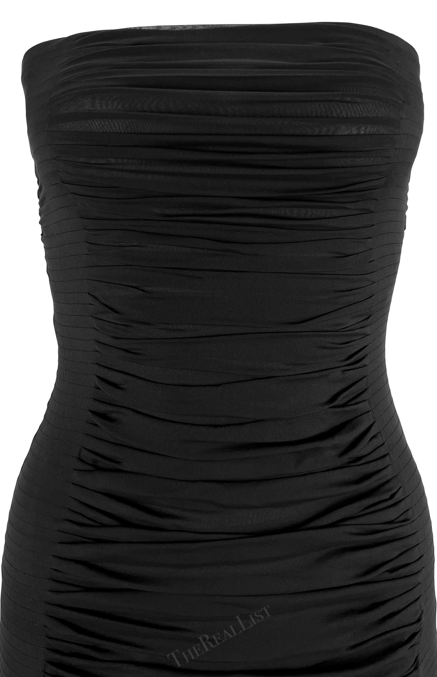 Présentation d'une fabuleuse mini robe bustier noire Yves Saint Laurent Rive Gauche, dessinée par Tom Ford. Issue de la collection printemps/été 2001, cette robe bustier chic est confectionnée en mousseline de soie légère et présente des ruchés et