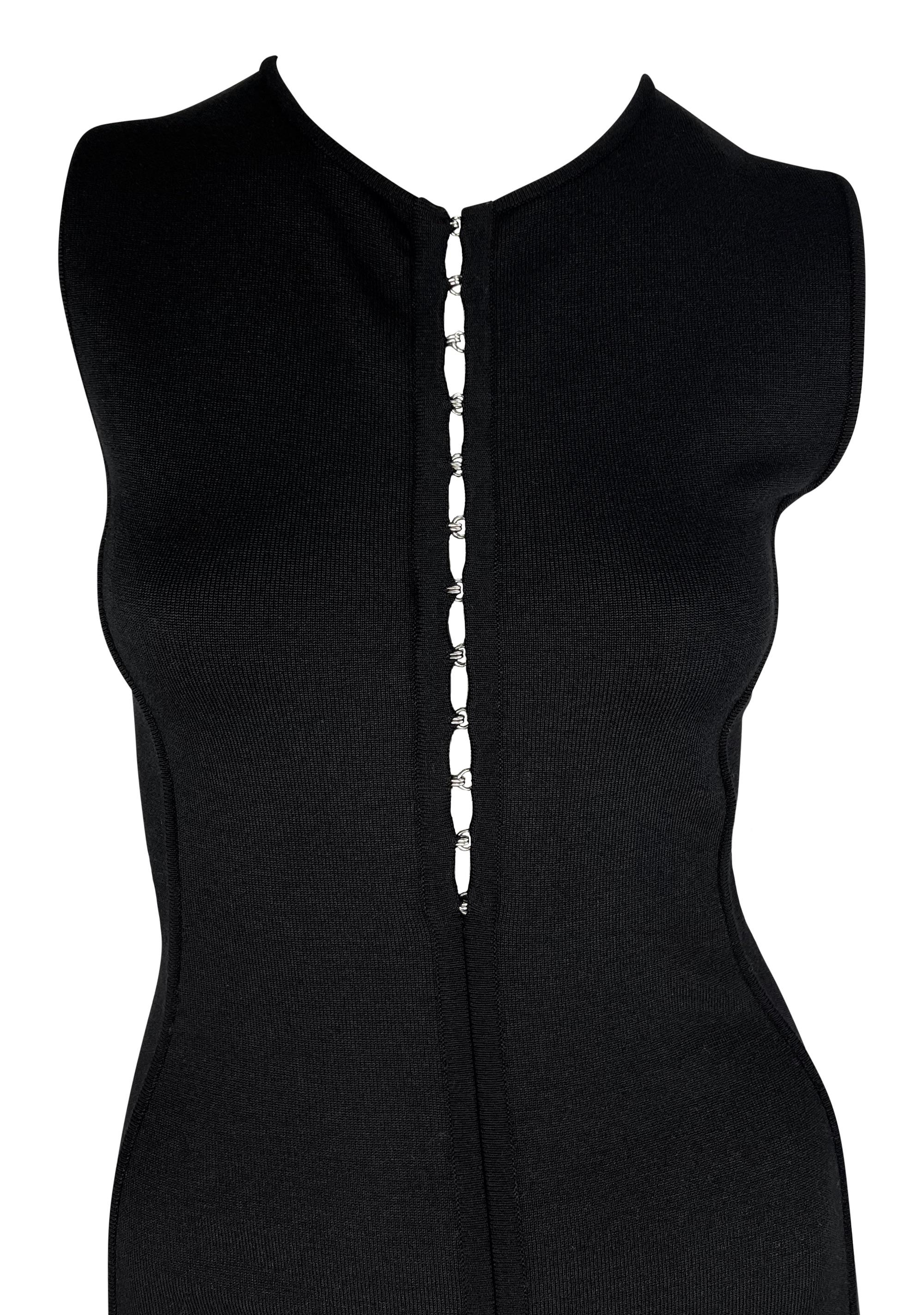 Donatella Versace designed this black knit Gianni Versace bodycon dress for the Spring/Summer 2002 collection. This sleeveless little black dress features a crew neckline and is complete with a silver hook and eye closures running down the front.