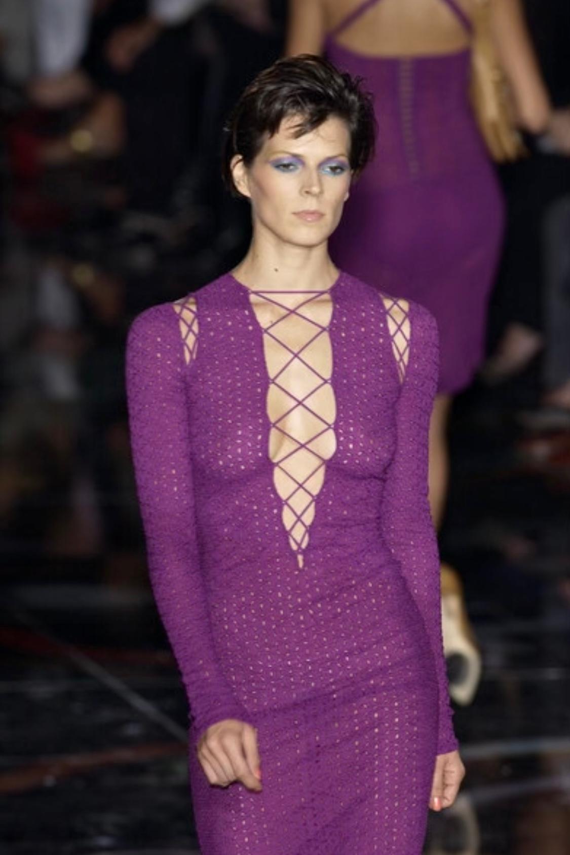 Presenting a purple plunging eyelet dress designed by Donatella for the Gianni Versace Spring/Summer 2002 collection. The eyelets that cover every inch of this dress give it a flirty sheer effect.  The plunging neckline is accented with a lace-up