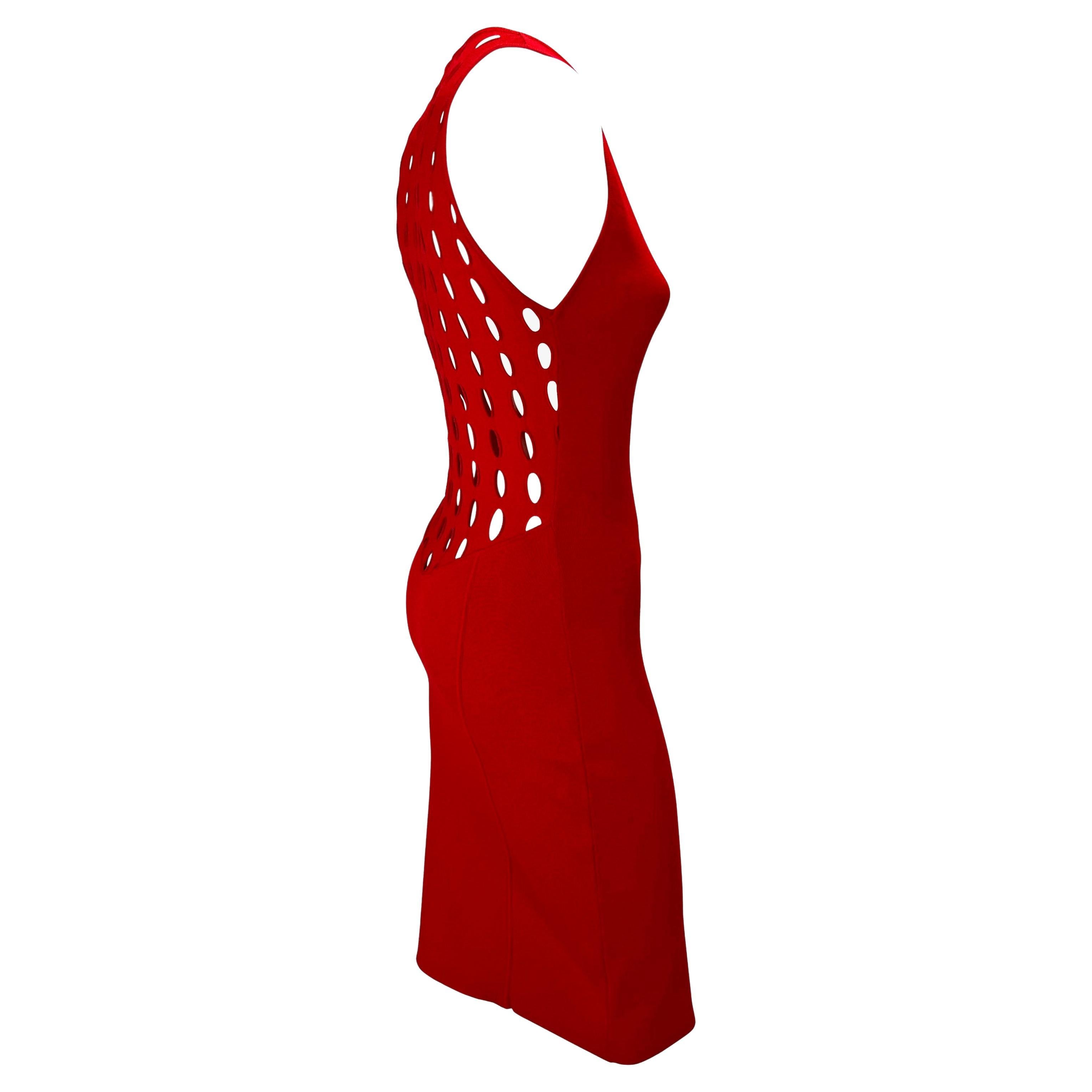 Presenting a bright red eyelet cut-out Gianni Versace Couture dress, designed by Donatella Versace. From the Spring/Summer 2002 collection, this vibrant sleeveless dress features a wide crew neckline and eyelet cutouts at the back. This form-fitting
