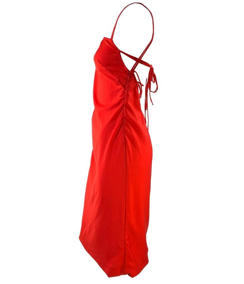 Présentation d'une robe à lacets Gianni Versace Couture, dessinée par Donatella Versace. Cette robe rouge vif a été lancée avec la collection printemps/été 2002, et des vêtements similaires ont été présentés sur les podiums de la saison. Sur le