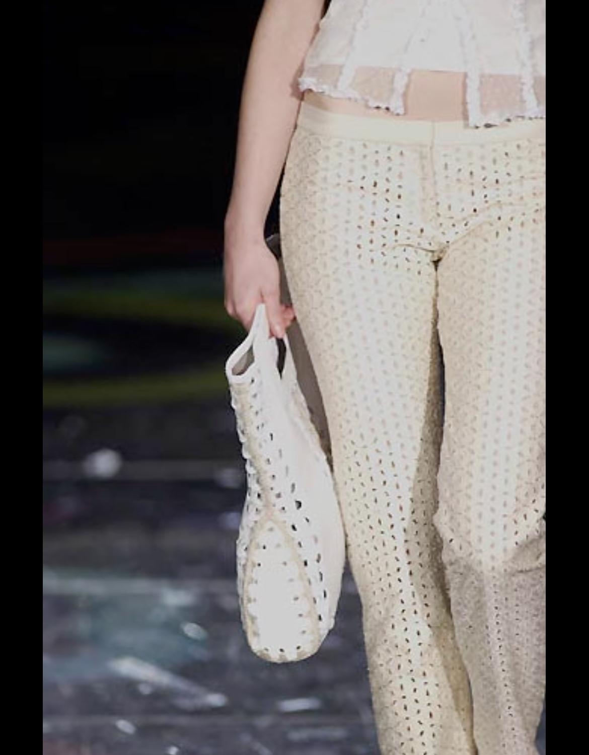 De la colección Gianni Versace Collection Primavera/Verano 2002 de Donatella Versace, este pantalón blanco roto presenta un tejido de broderie anglaise transparente con intrincados detalles recortados. Este pantalón, que debutó en la pasarela como