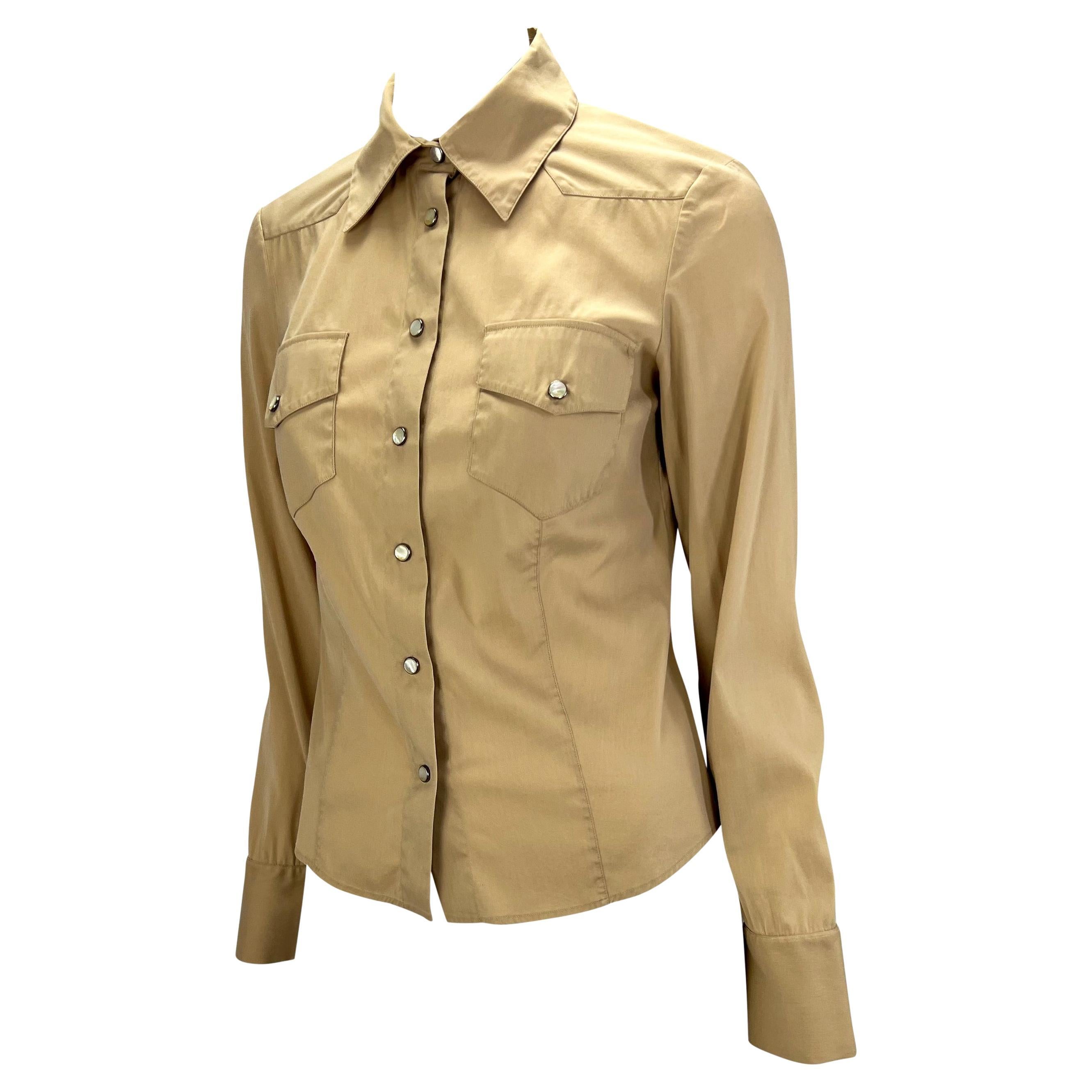 TheRealList presents: a sand-colored collared shirt with mother of pearl snap closure designed by Tom Ford for Gucci's Spring/Summer 2002 collection. Two snap pockets at the bustline accent the tapered western construction of this stretch blouse.