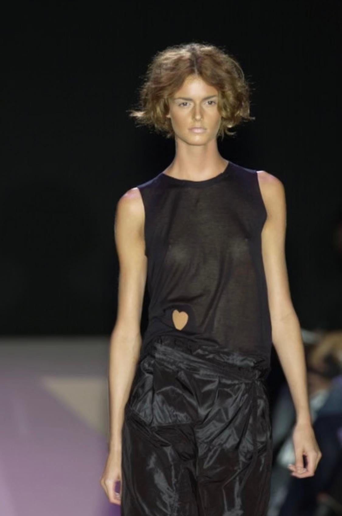TheRealList presents: a black sleeveless Gucci shirt, designed by Tom Ford. From the Spring/Summer 2002 collection, this top debuted on look 33 modeled by Jacquetta Wheeler with the white version debuting as look 3 modeled by Abbey Shaine. This