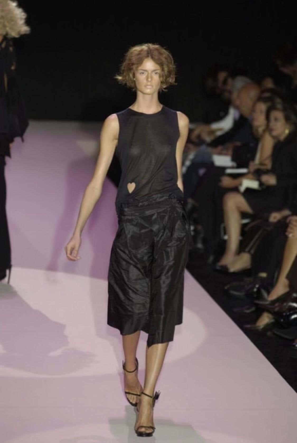 Presenting a black sleeveless Gucci shirt, designed by Tom Ford. From the Spring/Summer 2002 collection, this top debuted on look 33 modeled by Jacquetta Wheeler with the white version debuting as look 3 modeled by Abbey Shaine. This semi-sheer top