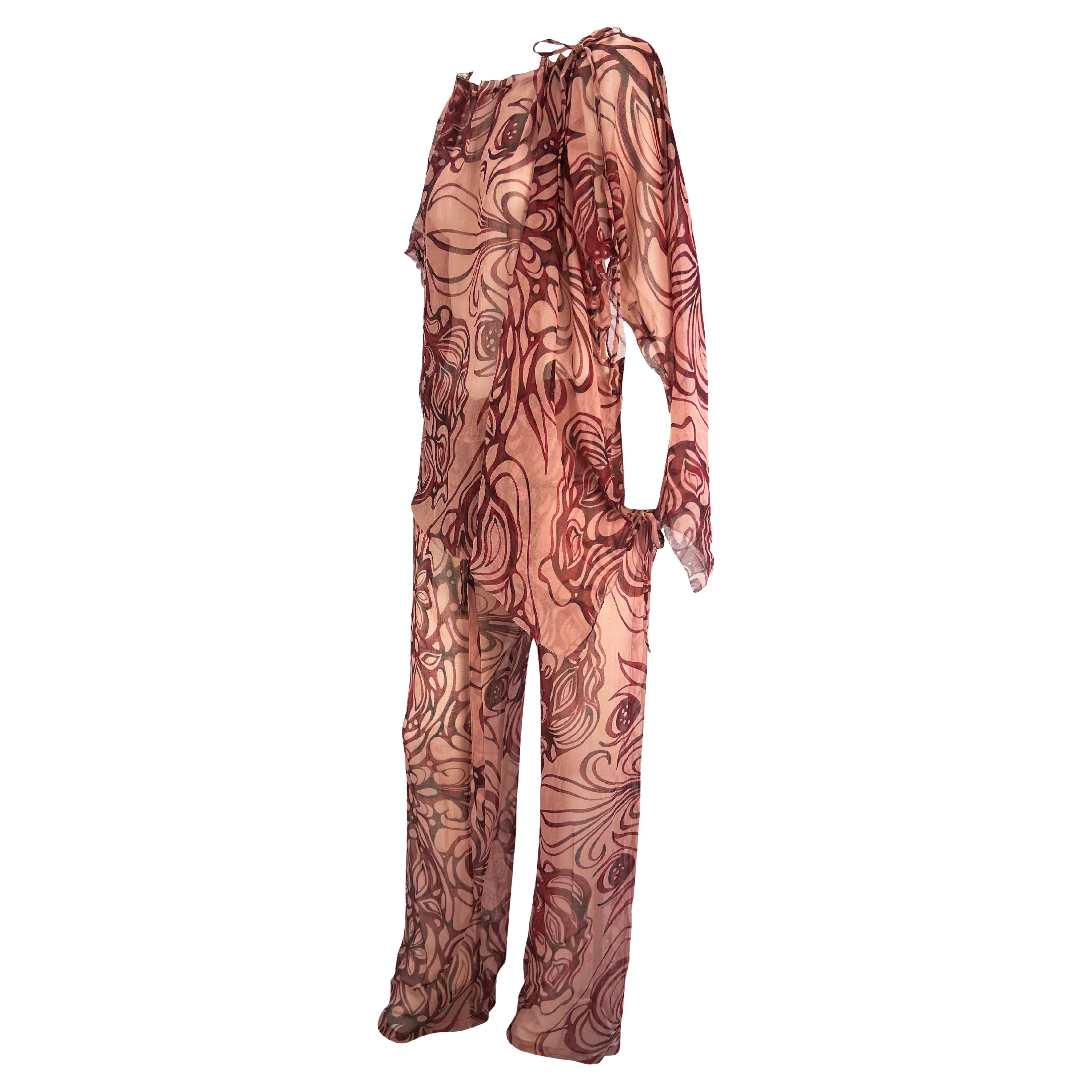 Presenting a matching floral sheer Gucci beach cover up set, designed by Tom Ford. From the Spring/Summer 2002 collection, this poncho and pant set feature beige fabric with a red and black floral/tattoo print. A rare find, the poncho features