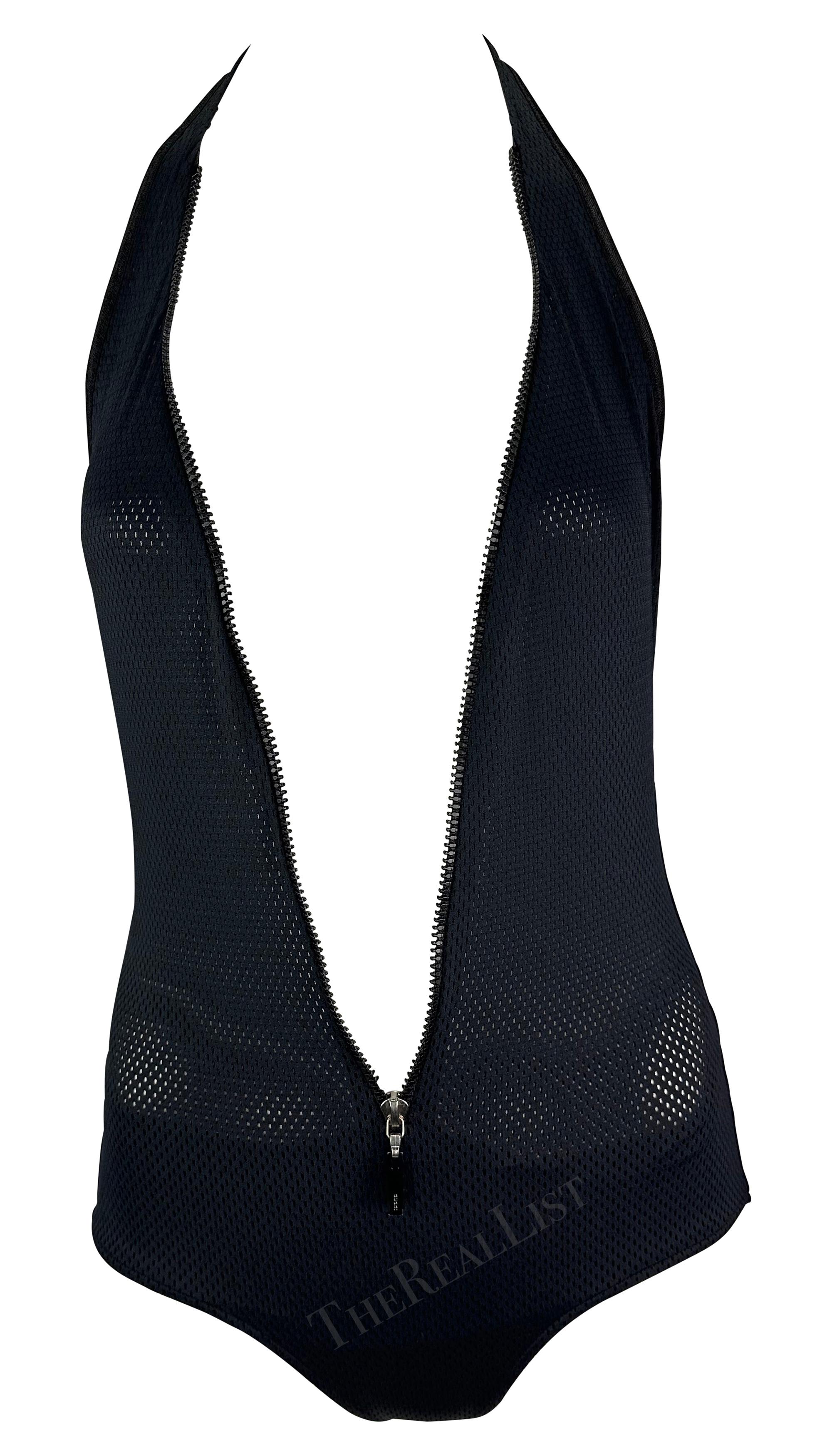 Presenting an ultra-sexy black mesh Gucci one-piece swimsuit, designed by Tom Ford. From the Spring/Summer 2002 collection, this mesh one-piece features a halter neck and zipper that runs downs the front. The zipper runs down to just above the hip