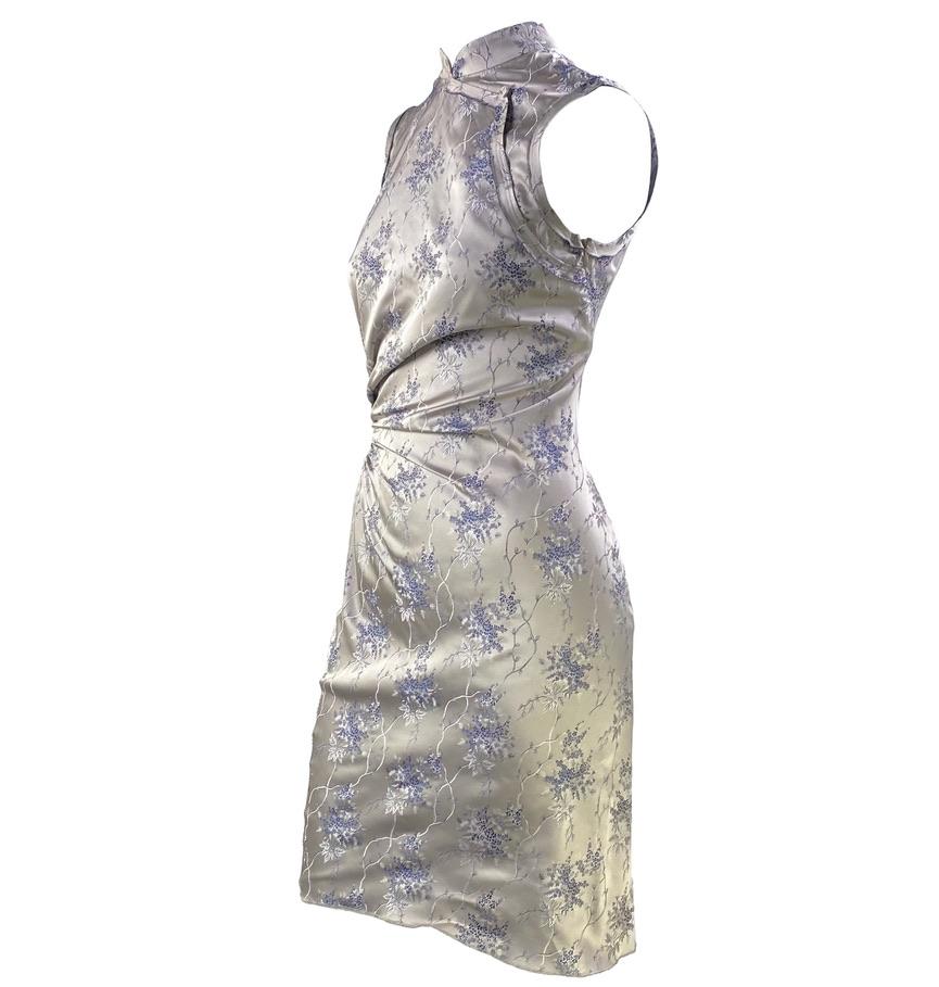 TheRealList präsentiert: ein Prada-Kleid im Cheongsam-Chinoiserie-Qipao-Druck. Dieses atemberaubende Seidenkleid aus der Frühjahr/Sommer-Kollektion 2002 hat einen Stehkragen, einen hohen Ausschnitt und seitliche Rüschen. Das gesamte Kleid ist aus