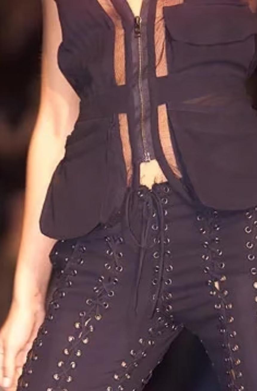 Presenting a pair of lace-up Yves Saint Laurent Rive Gauche pants, designed by Tom Ford. From the Spring/Summer 2002 Safari collection, these black pants feature lace details on both sides, at the waist, and crotch. Many looks on the season's runway