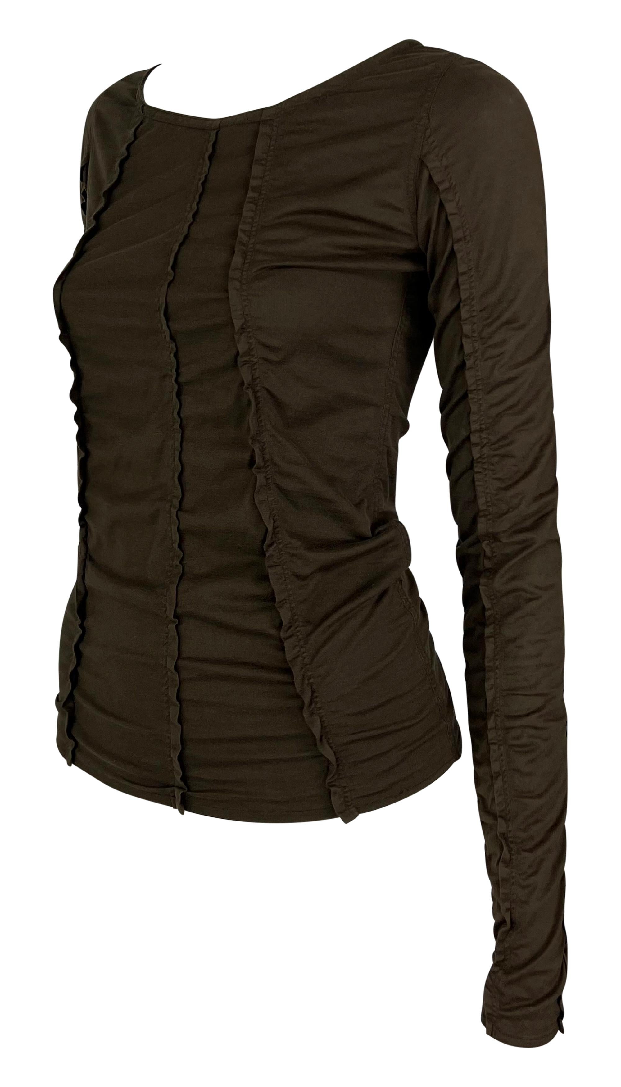 Disegnato da Tom Ford per la collezione primavera/estate 2002 di Yves Saint Laurent, questo top marrone a maniche lunghe presenta una silhouette aderente. Il design è realizzato con pannelli asimmetrici, ognuno dei quali aggiunge consistenza e