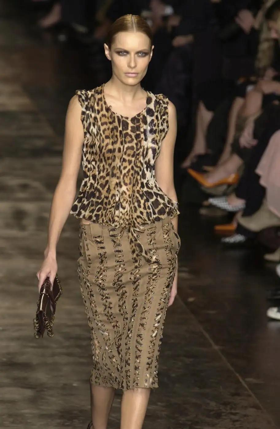 Ti presentiamo un top chic Yves Saint Laurent Rive Gauche, con stampa giaguaro, disegnato da Tom Ford per la primavera/estate 2002. Questo capo presenta una scollatura a palloncino, maniche corte oversize e un sottile orlo a peplo. Realizzato con