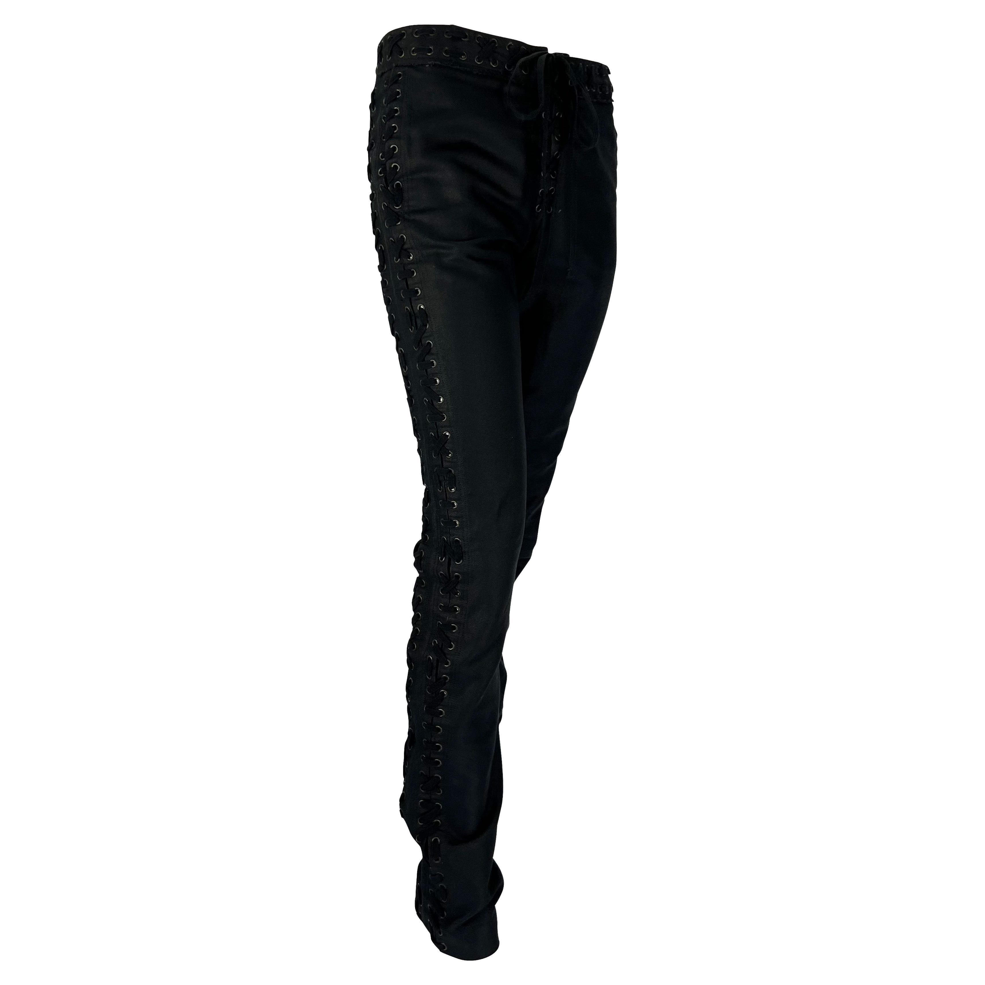 Presenting a pair of lace-up Yves Saint Laurent Rive Gauche pants, designed by Tom Ford. From the Spring/Summer 2002 Safari collection, these black pants feature lace details on both sides, at the waist, and crotch. Many looks on the season's runway