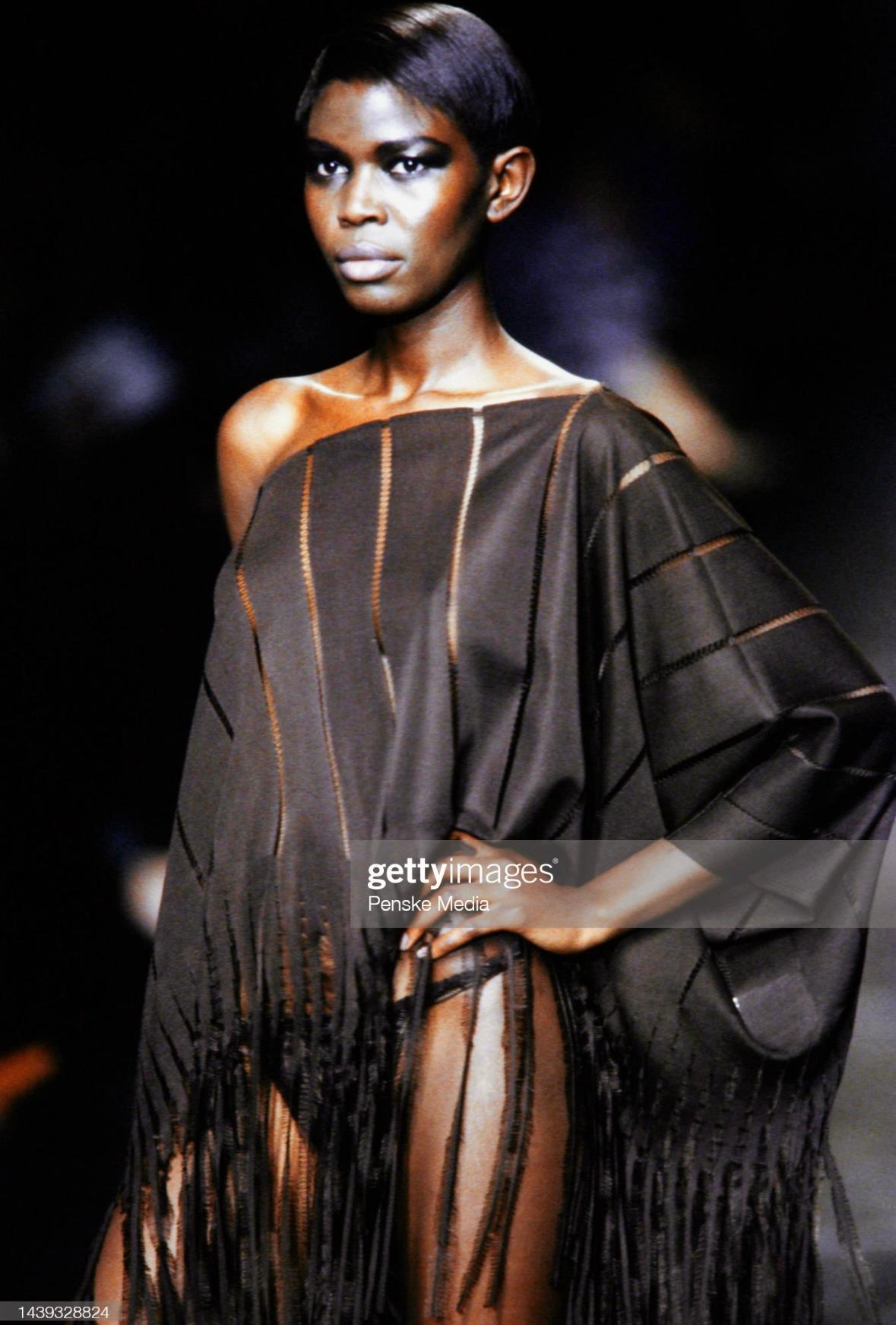 Presenting an absolutely fabulous black Yves Saint Laurent Rive Gauche caftan poncho, designed by Tom Ford. From the Spring/Summer 2002 collection, this caftan debuted on the season's runway as look 37 modeled by Caroline Bwonobo and was featured in