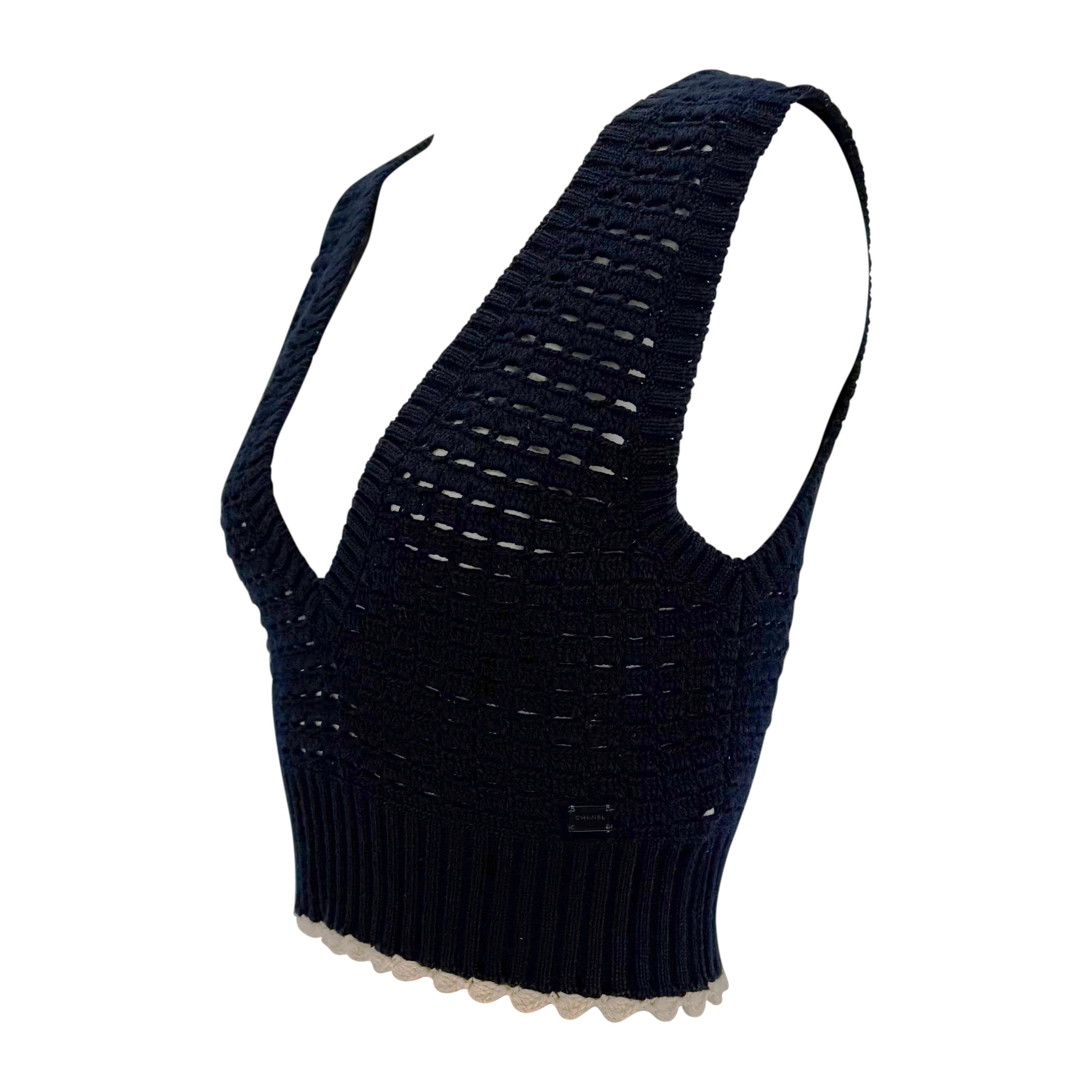 From Chanel’s Spring/Summer 2003 collection by Karl Lagerfeld, this navy blue cropped vest is crafted in an open crochet knit with a deep V-neckline and contrasting hem. Finished with a subtle scalloped edge and signature logo tag at the